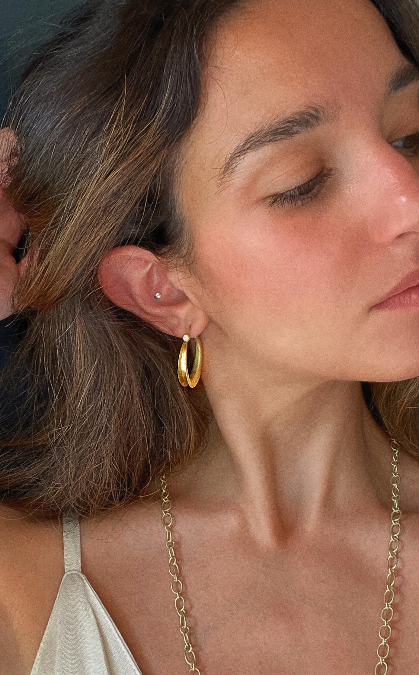 Faye Kim's 18 Karat Gold Diamond Anticlastic Hoop Earrings allow for strength and durability without added weight. The modern yet classic style features hoops finished with a bezel set diamond, adding the perfect amount of sparkle. 

Hoop length