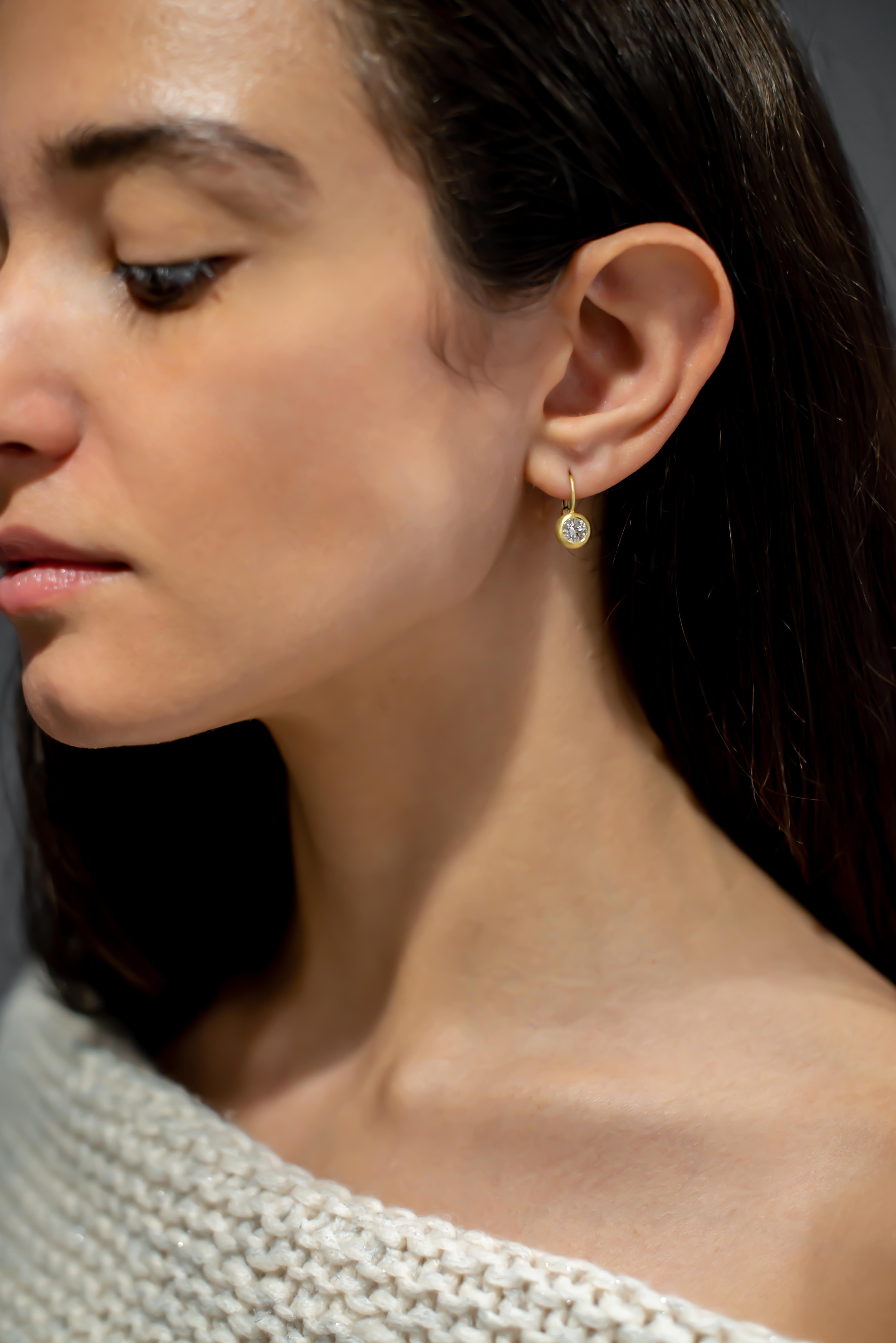 The ultimate beauty in simplicity!
White, round brilliant cut diamonds are set in 18k gold, domed bezels and finished with secure lever-backs. Earrings hang perfectly, just below the earlobe, providing a bit of sparkle with each movement. 

Diamond: