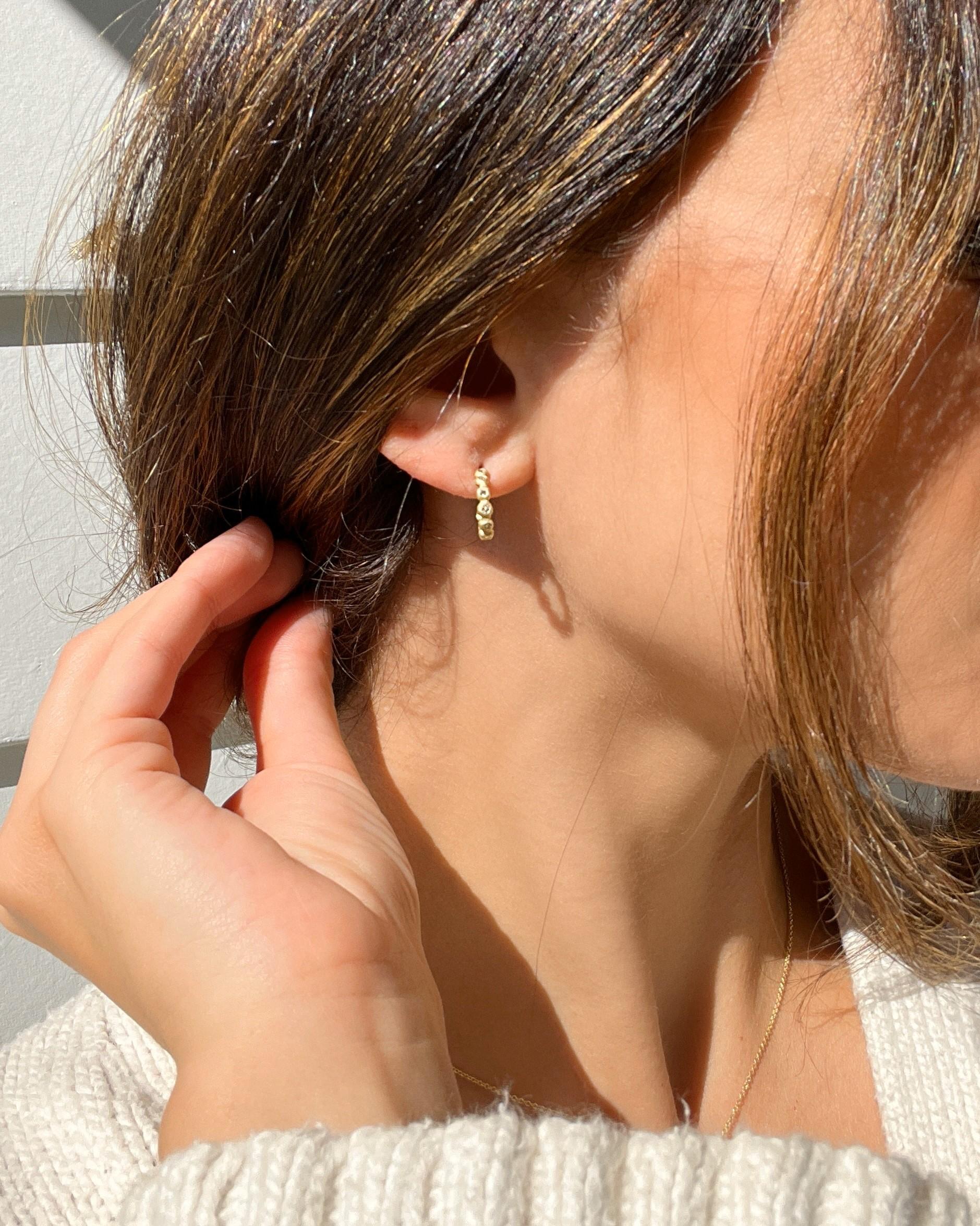 Realizzato a mano in oro 18 carati, il moderno cerchio a granulazione di Faye Kim è un look da indossare tutti i giorni! La caratteristica finitura opaca esalta lo scintillio dei diamanti e trasmette una sobria eleganza. 

Diamanti = .27 cts