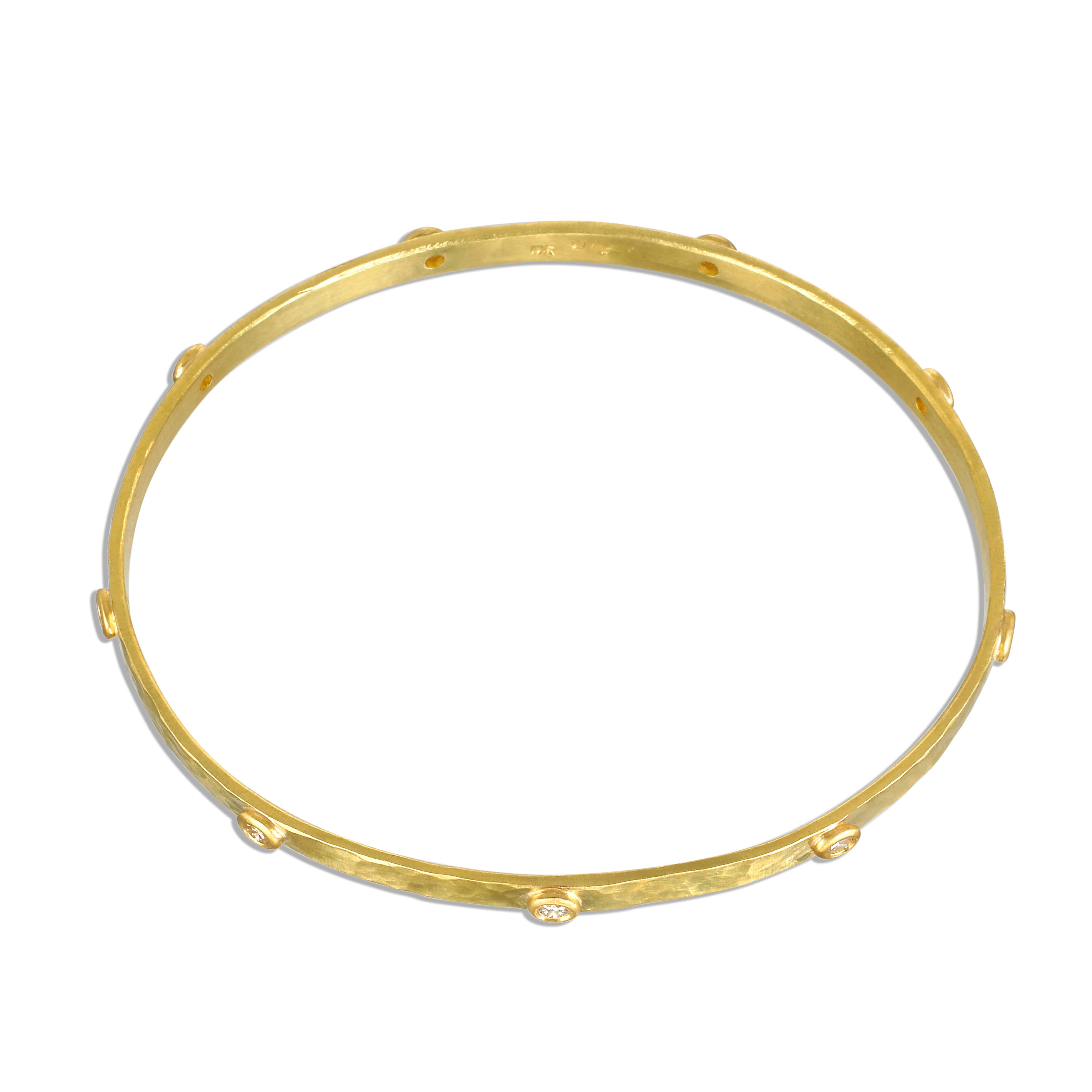 Handcrafted in 18 karat gold, Faye Kim’s modern design incorporates bezel-set diamonds into this hammered oval bangle bracelet that is both organic and timeless in feel. Exuding an understated elegance, this bangle can be worn alone or stacked with