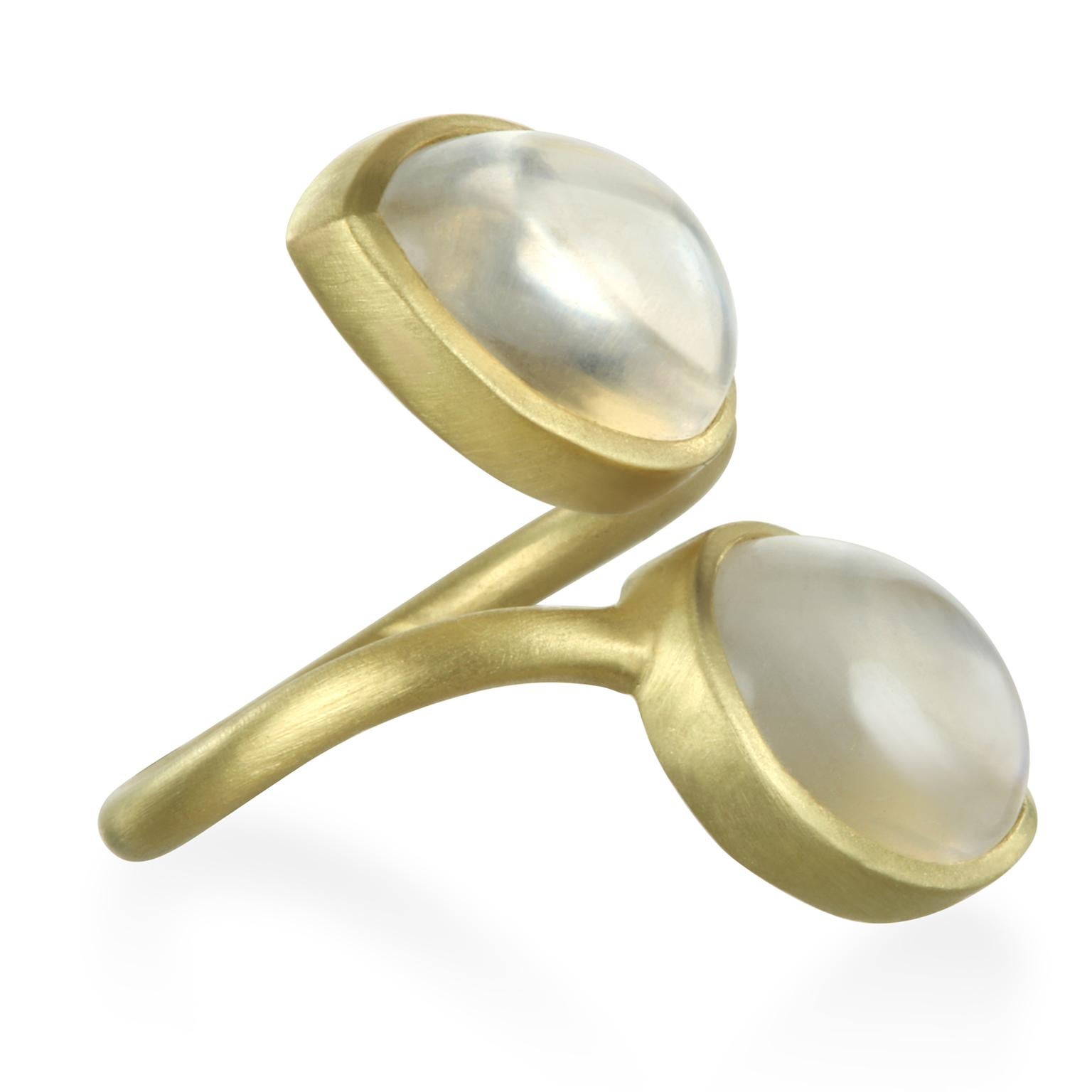 This bold and beautiful 18k Gold Double Pear Shape Moonstone Bezel Ring makes quite a statement. The matte gold enhances the moonstones striking rainbow effect. Featuring matched luminescent moonstone cabochons, the shape and polish of the stones