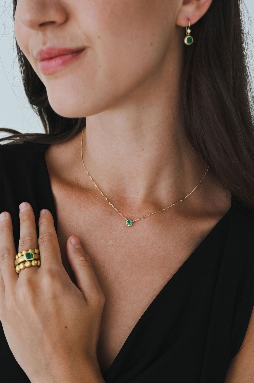 One of a kind and handcrafted in 18 karat gold, Faye Kim's Emerald Bezel Pendant Necklace is matte finished and perfect for layering with other necklaces or wearing alone. This piece is sure to become one of your go-to favorites!

Emerald .45