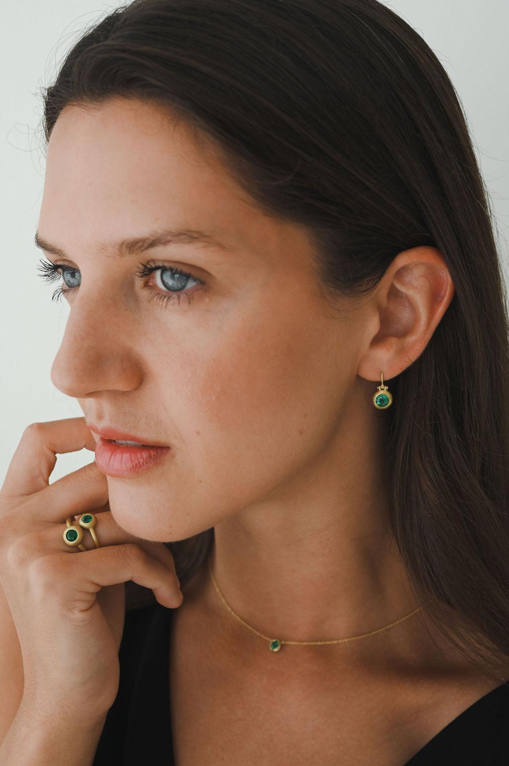 Faye Kim's 18 Karat Gold Emerald Domed Hinge Earrings feature emeralds set in a classic matte finished dome bezel and attached to ear wires. The hinge detail adds movement while the bezel setting makes the emeralds sparkle.

Emeralds .75 Carats