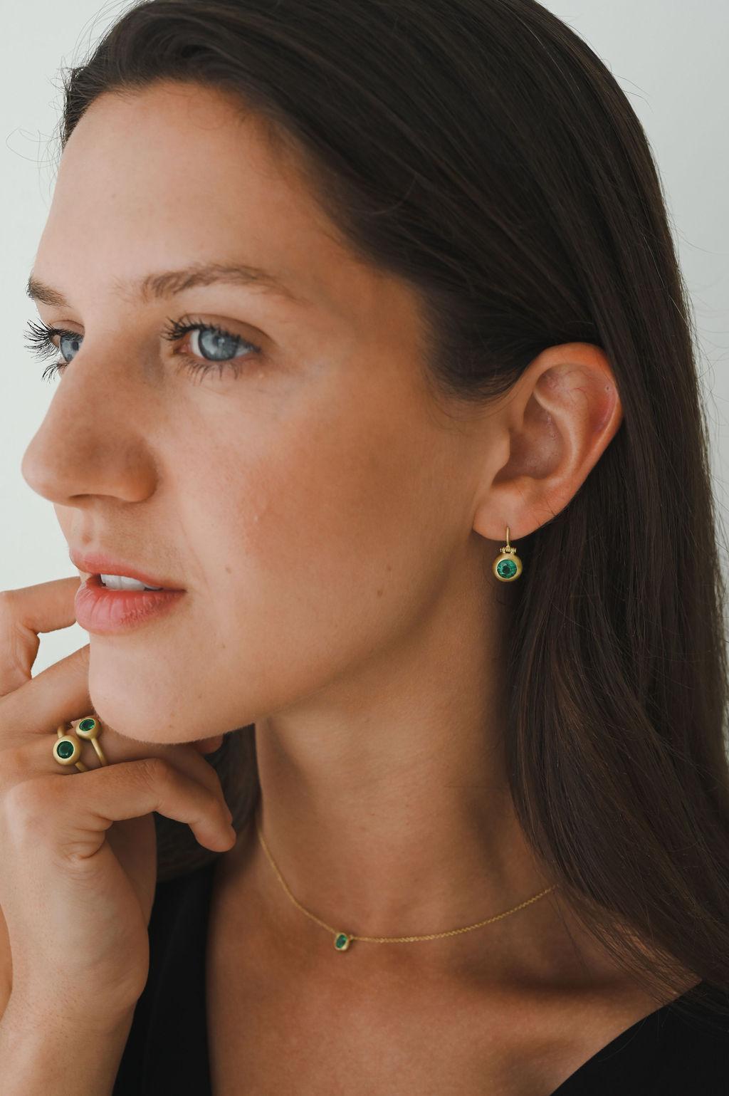 Faye Kim's 18 Karat Gold Emerald Domed Hinge Earrings feature emeralds set in a classic matte finished dome bezel and attached to ear wires. The hinge detail adds movement while the bezel setting makes the emeralds sparkle.

Emeralds 1.65 Carats