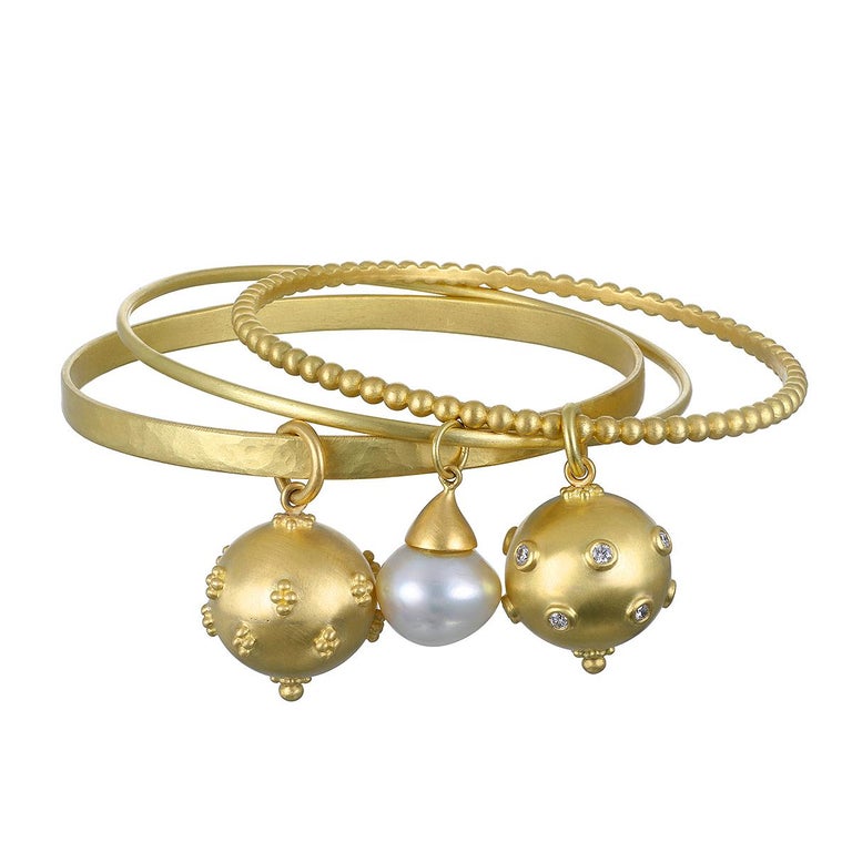Faye Kim's 18 Karat Gold Granulation Bead Bangle with Diamond Ball Charm is sure to be a conversation starter, whether worn alone or stacked with other bracelets.

Charm diameter  .75