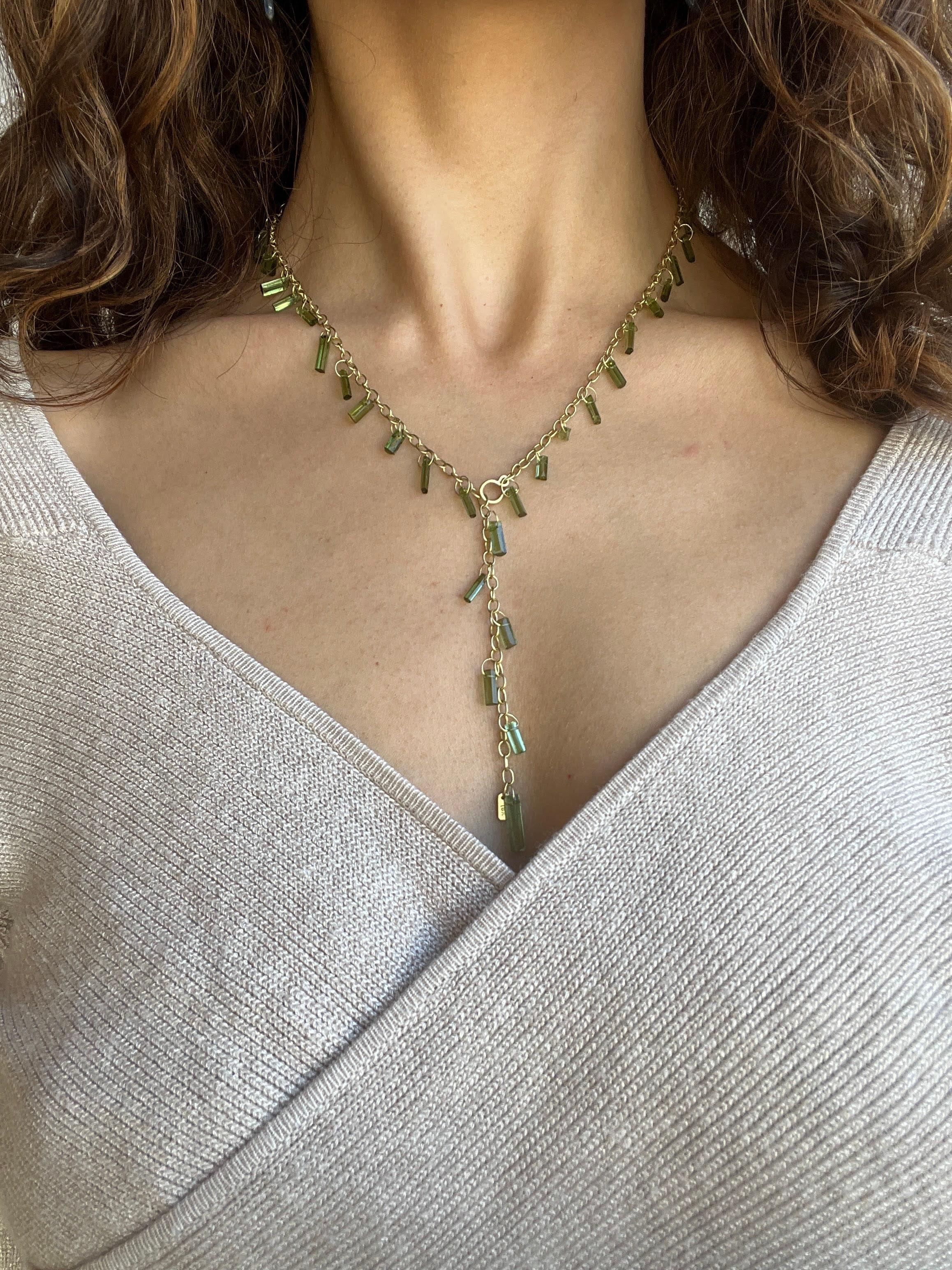 Le Lariat à franges en cristal de tourmaline verte en or 18 carats de Faye Kim Designs présente un design moderne d'une élégance discrète. Cette pièce remarquable, avec ses barres de tourmaline scintillantes suspendues à une chaîne à maillons