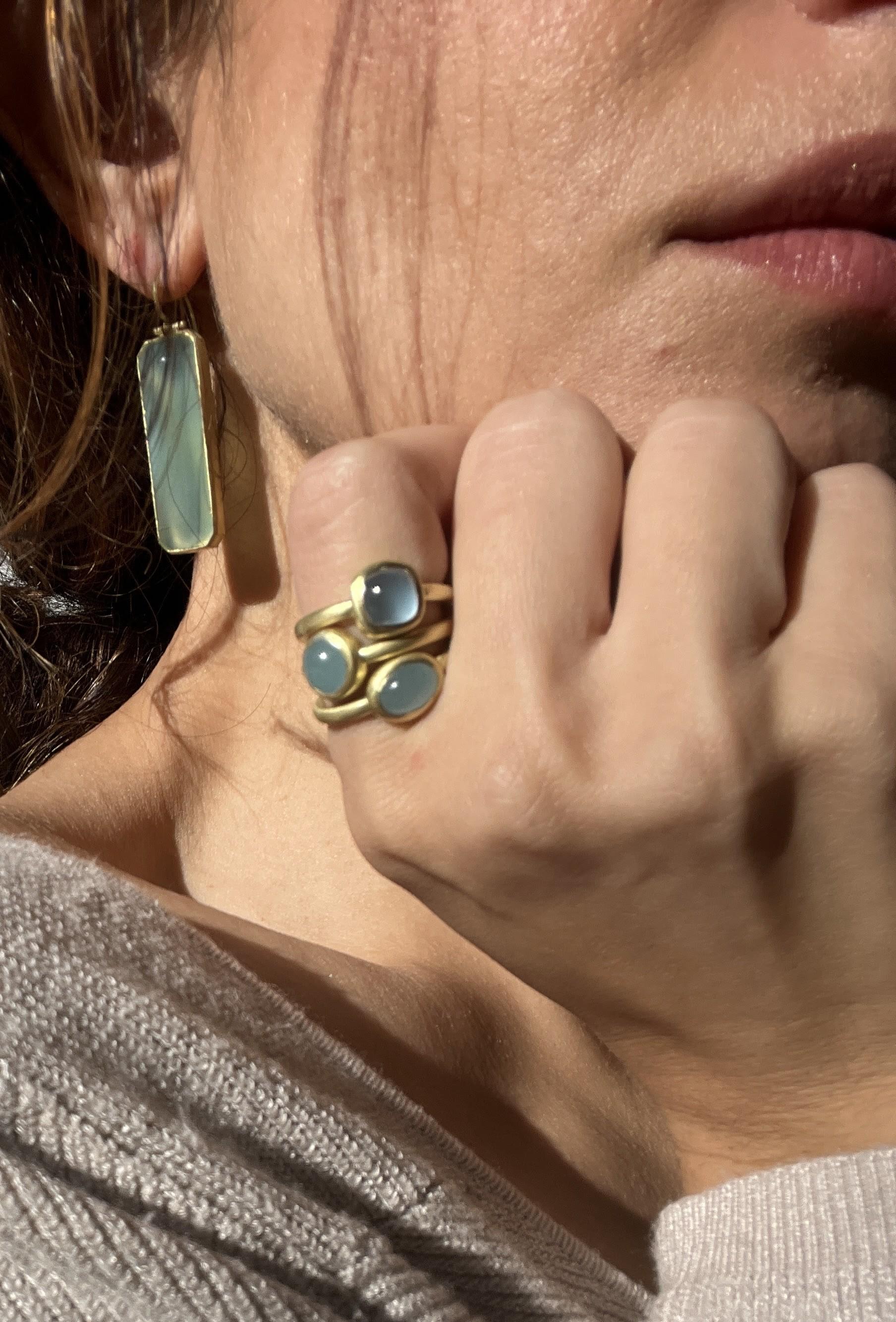 Faye Kim's beautiful Round Milky Aqua Bezel Ring is handcrafted in 18 Karat Gold. The clean bezel setting and matte gold finish enhance the stone's natural blue gray color. Wear alone or stacked with other for a truly stylish, modern, everyday