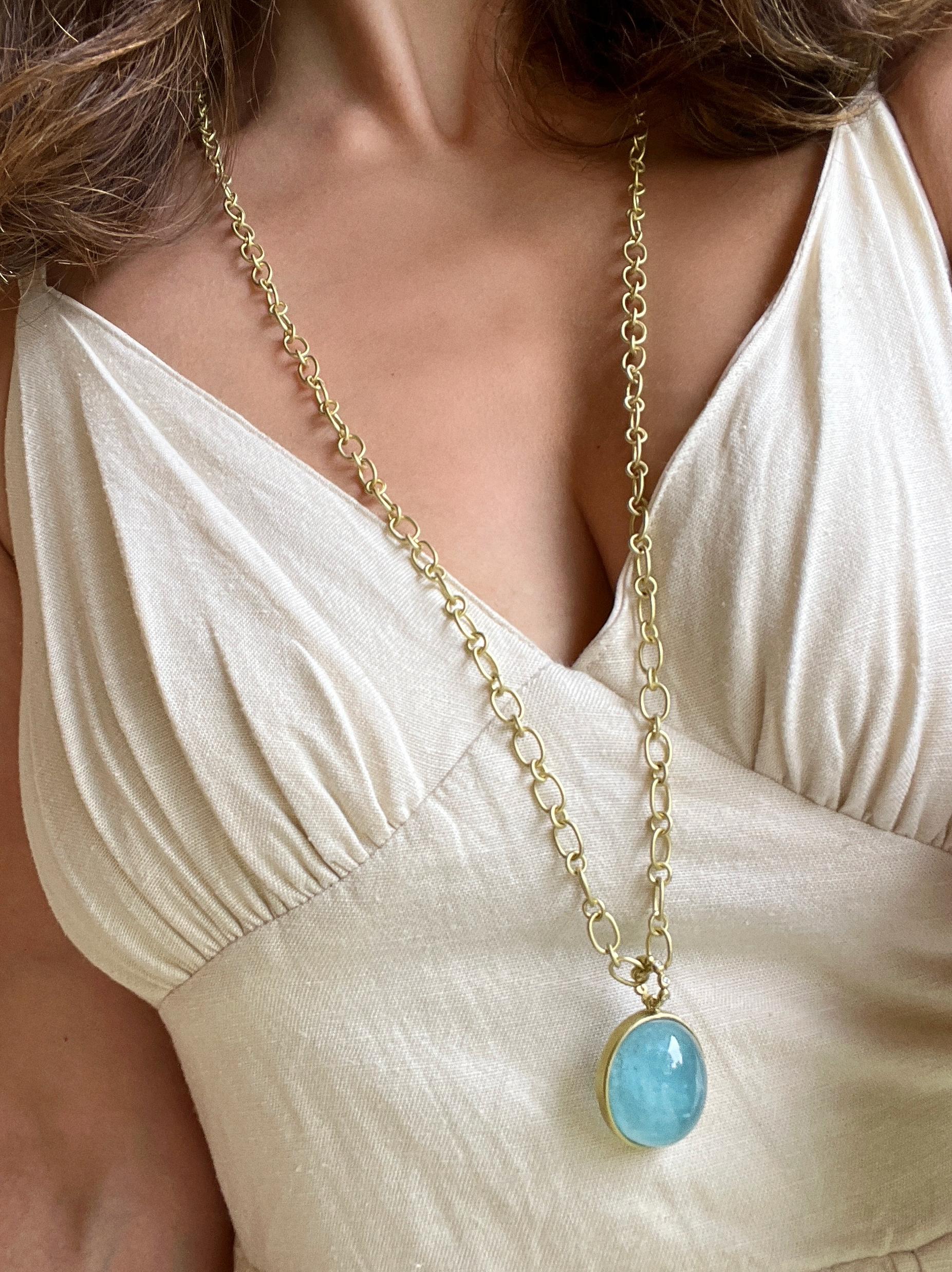 Faye Kim's spectacular Milky Aquamarine Oval Cabochon Pendant is a one-of-a-kind piece, handcrafted and bezel set in 18 karat gold. The soft, ethereal blue is enhanced by the white diamonds in the bail.  

Aquamarine 47.3 carats
Pendant length 1.5