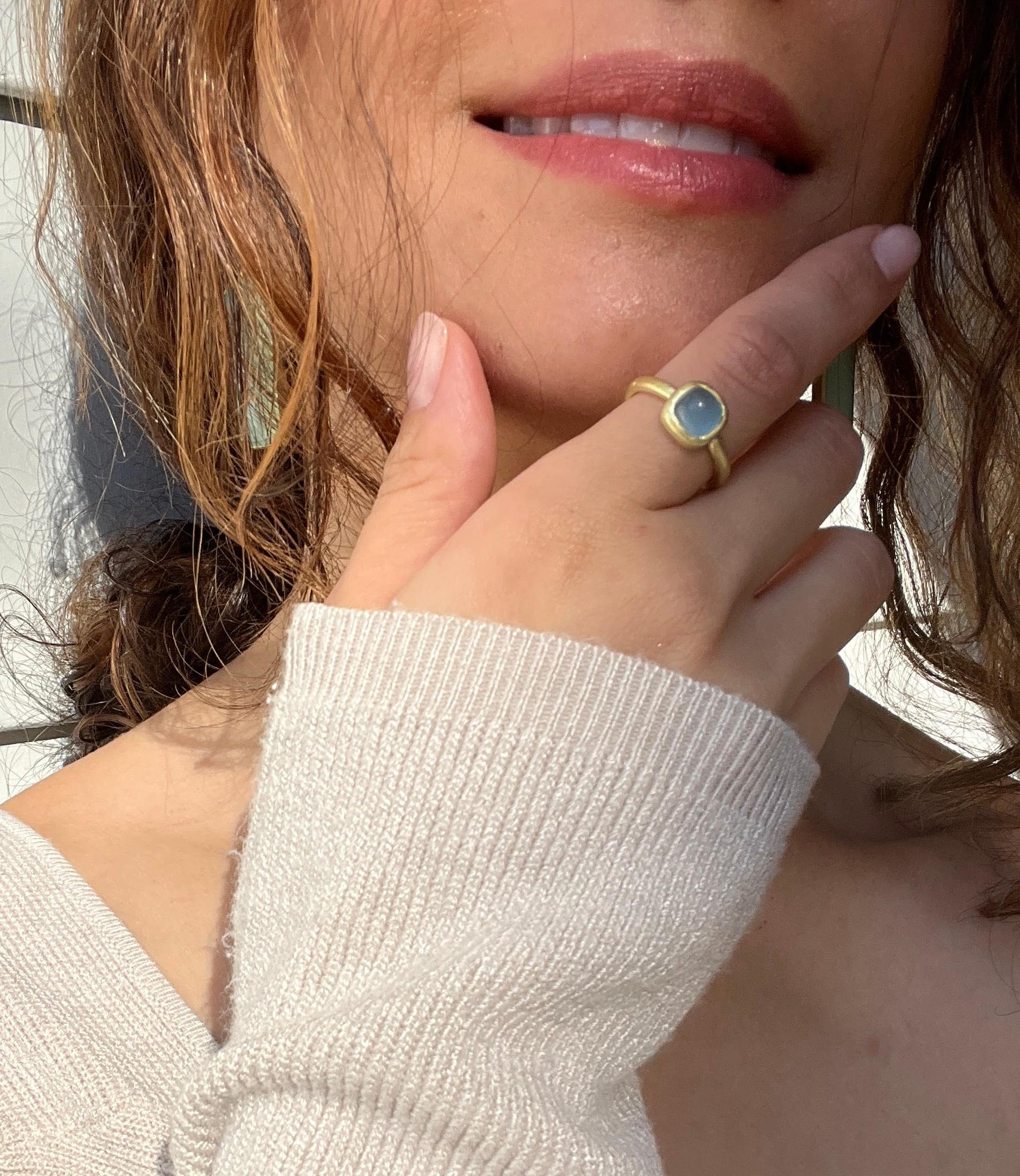 Faye Kim's beautiful Milky Aquamarine Cushion Bezel Ring is handcrafted in 18 karat gold. The clean bezel setting and matte gold finish enhance the stone's natural translucent aqua color. 

Size 6.75

Made in the USA
