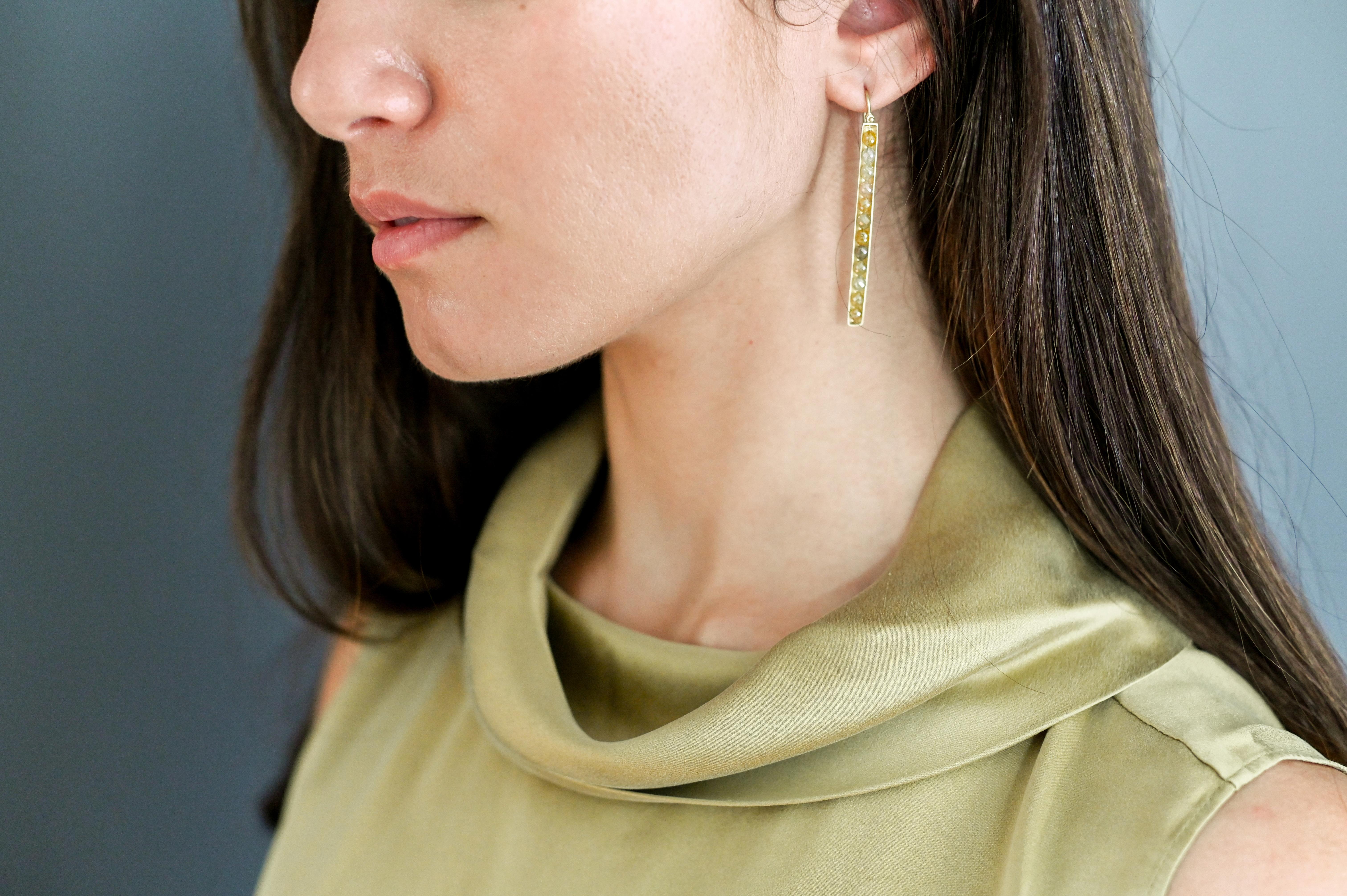Femeninos pero atrevidos, los pendientes estilo cerilla de oro de 18k llevan diamantes amarillos engastados en canal para un aspecto limpio y elegante.  El detalle de la bisagra proporciona movimiento y brillo. Acabado mate.

Diamantes: color