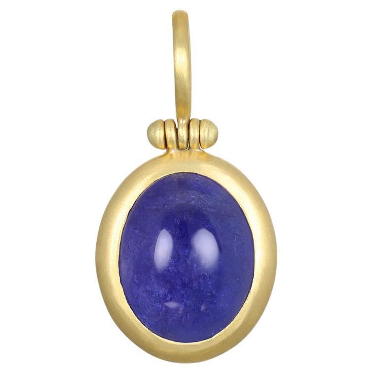 Faye Kim's 18 Karat Gold Tanzanite Cabachon Hinged Ball Pendant, with its striking blue hue, is sure to make a design statement! This unique, one of a kind piece is finished with Faye's signature clean bezel and hinged bail. Paired with 18 Karat