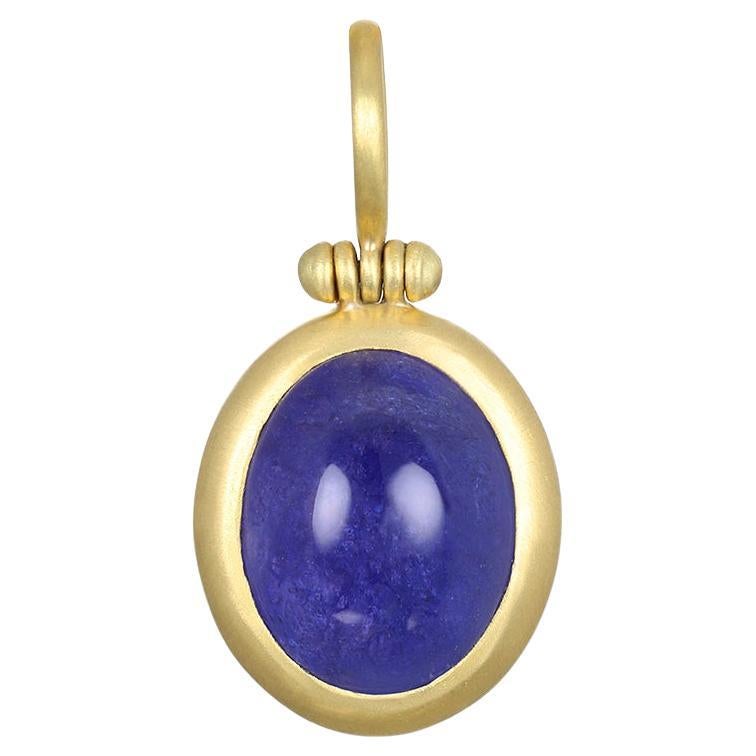 Faye Kim's 18 Karat Gold Tanzanite Cabachon Hinged Ball Anhänger, mit seinem auffälligen blauen Farbton, ist sicher ein Design-Statement! Dieses einzigartige Stück ist mit der für Faye typischen sauberen Lünette und dem Scharnierbügel versehen.