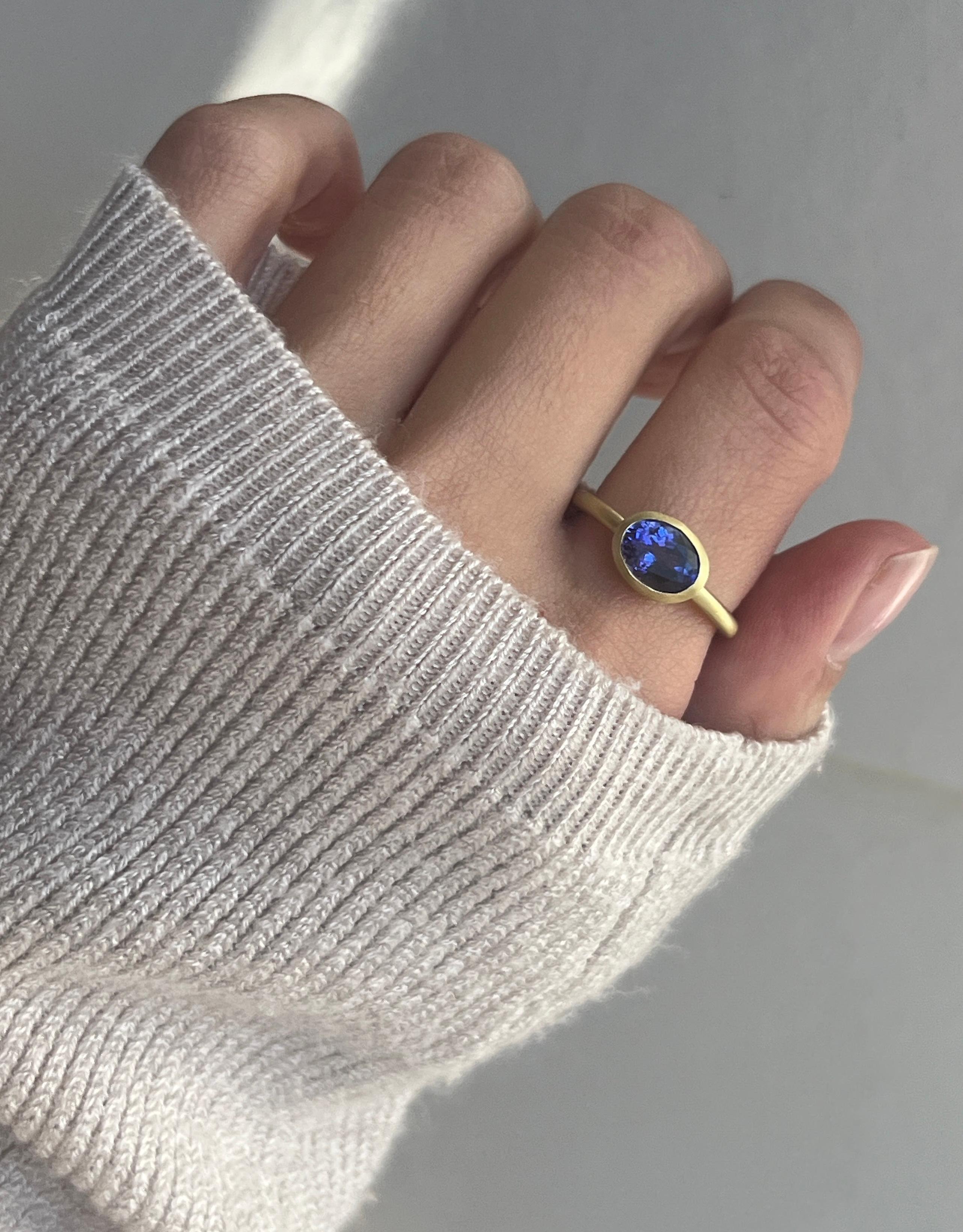 Faye Kim's 18 Karat Gold Tanzanite Oval Bezel Ring, with its intriguing blue-violet hue, is beautifully bezel set and matte finished. The ring can be worn alone or stacked with other rings.

Size 6.25, can be sized

Ring shown stacked with similar