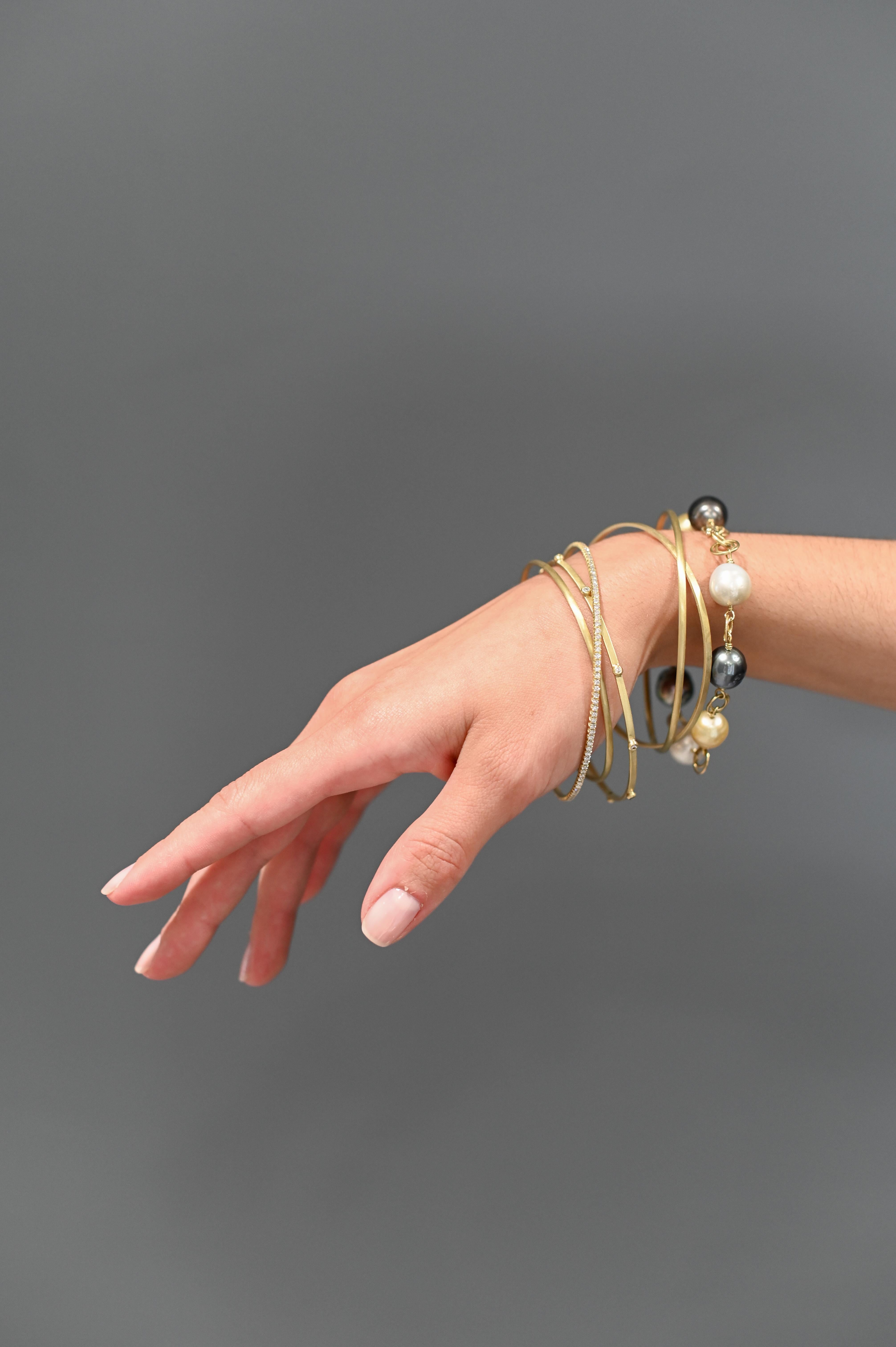Faye Kim's 18 Karat Gold Thin Bangles - sold individually - are fabricated from solid gold. The bangles can be worn alone or stacked with multiples for your unique style. 

Width 2mm
Sizes:   
     Small 2.5
