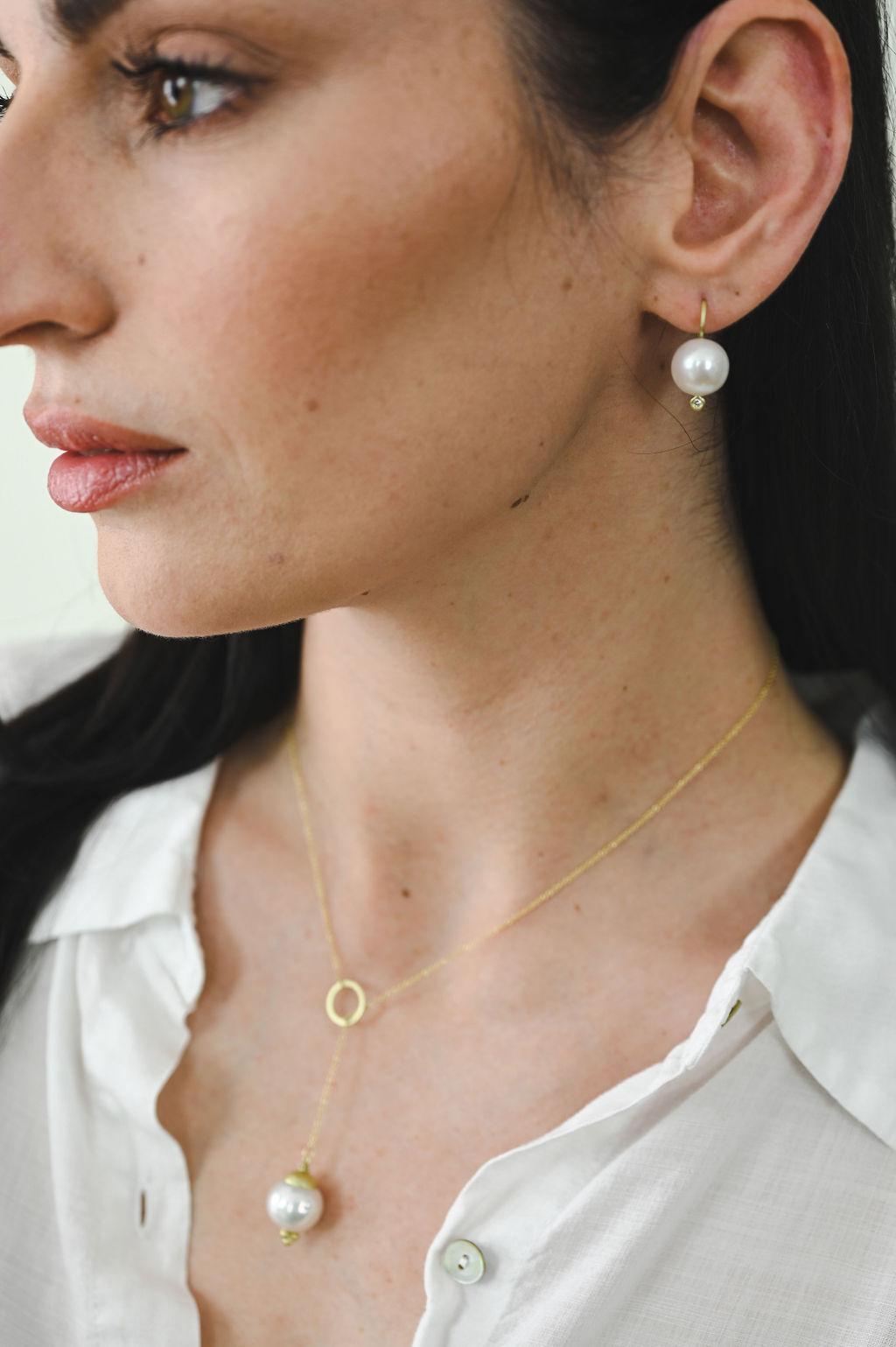 Faye Kim's White Freshwater Pearls on 18k gold ear wires feature a bright diamond at the earring base for a pretty pop of sparkle.

Diamonds .06 Carats tcw
Pearls 12-13mm
Length 0.75