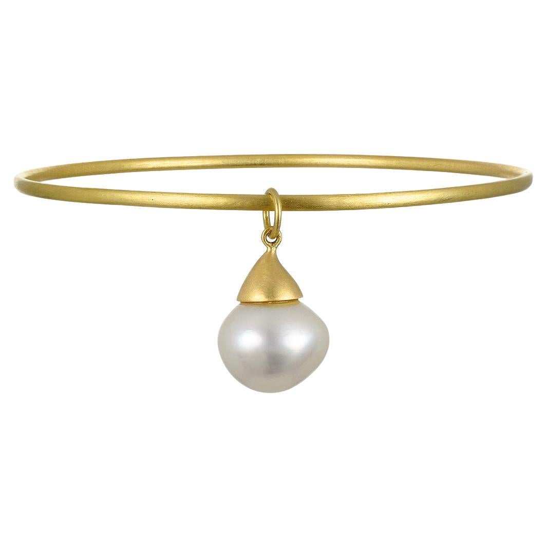 Faye Kim's 18k Gold White South Sea Pearl Charm is both classic and contemporary in its style. The lustrous pearl is complemented by its matte-finished gold cap. Can be paired with one of Faye's chains or bangles.

Pearl 11mm

Photos show similar