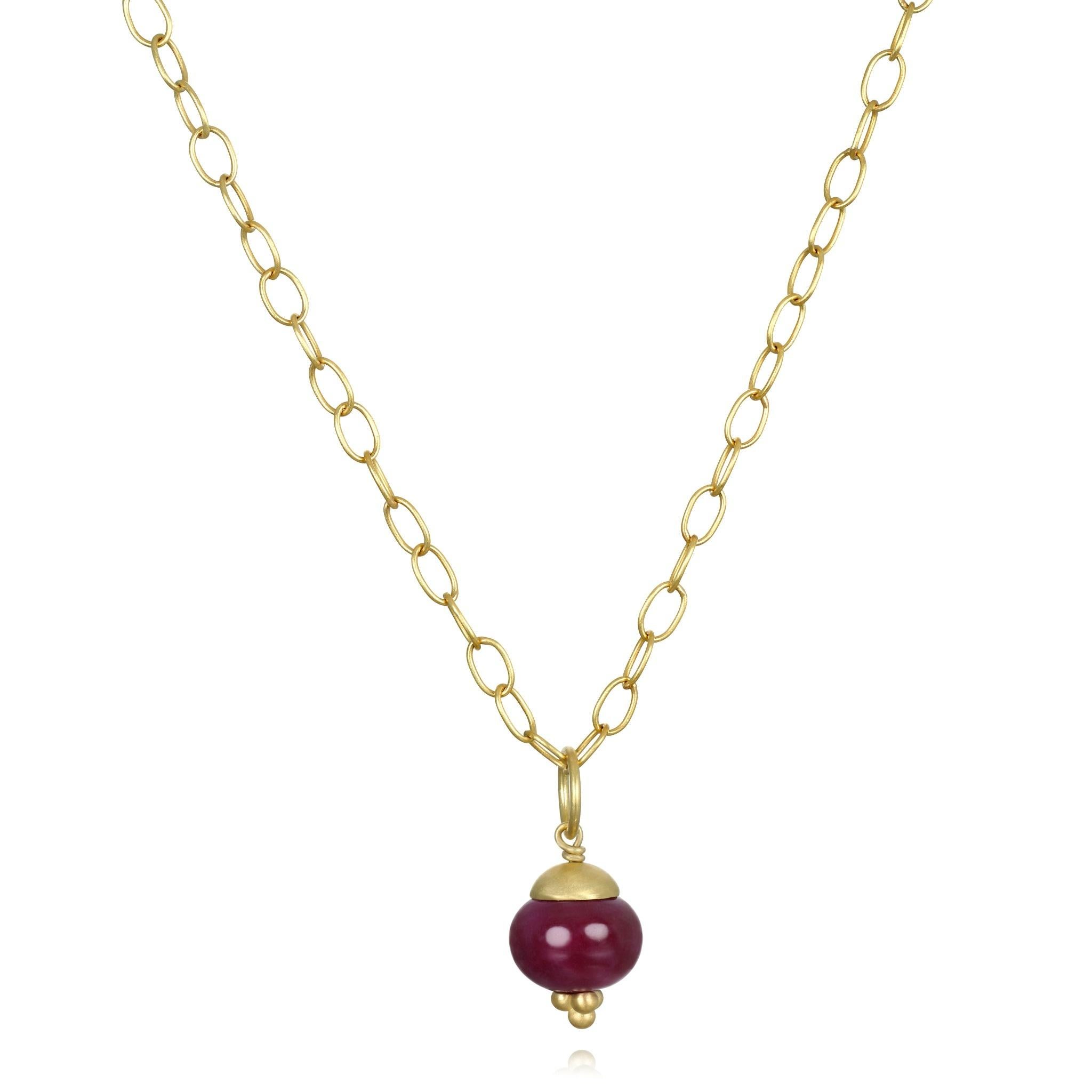 

Faye Kim's 18K Gold Natural Ruby Rondell Pendant features a cap and granulation detail and is handcrafted in her signature green gold with a matte finish. The pendant showcases a striking, rich crimson ruby weighing 16 carats. This versatile piece