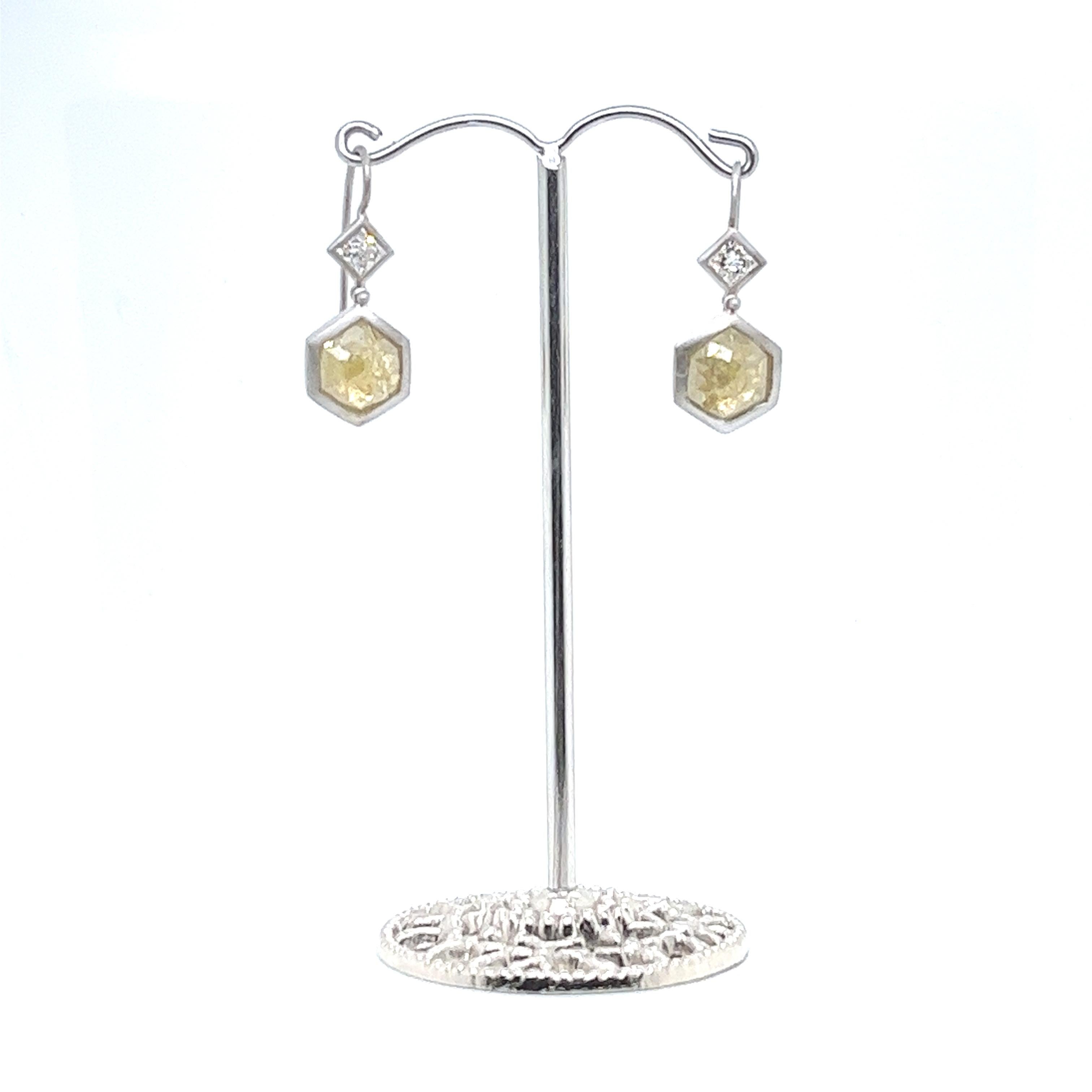 Faye Kim's one-of-a-kind 18 Karat White Gold Yellow-Green Milky Diamond Earrings comprise bezel-set stones that contrast beautifully with both each other and their white gold matte finish setting. Hinged ear wires allow for movement and show off the