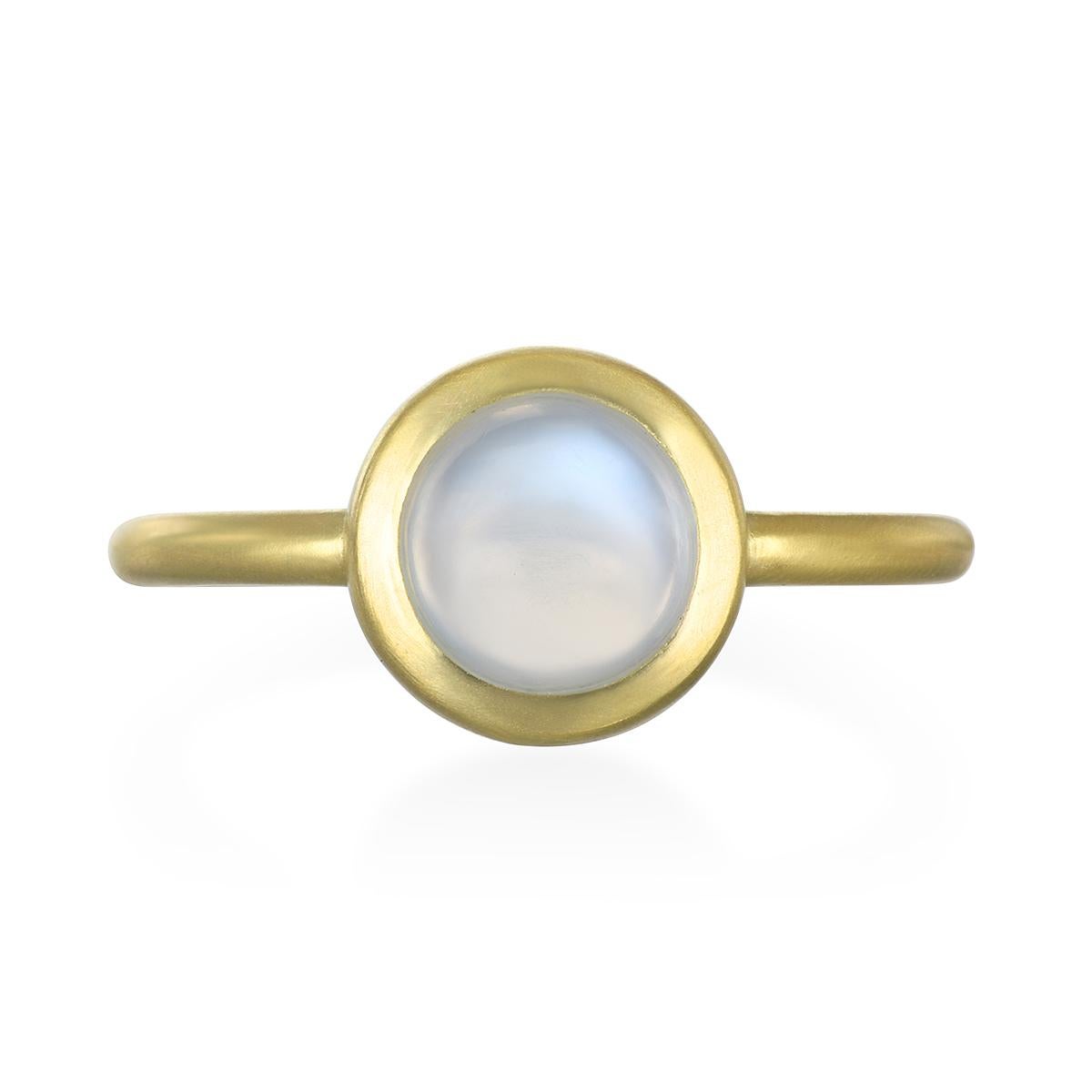 This beautiful Moonstone Bezel Ring is full of light and reflects beautiful translucent blue hues. The clean shape, polish, and matte gold enhances the moonstones glowing effect. Handcrafted in 18k gold, Faye Kim’s modern design conveys understated