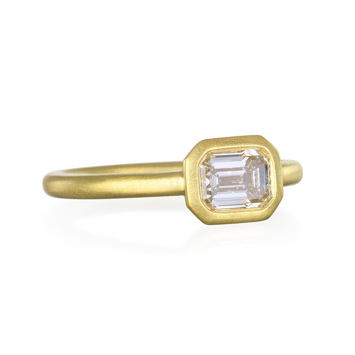 Faye Kim's Emerald Cut Diamond Ring is handcrafted in 18 karat gold. Set horizontally with a thin band, the stone is beautifully highlighted in a matte finished bezel for a clean, contemporary feel. Perfect for the modern bride or a right hand stack