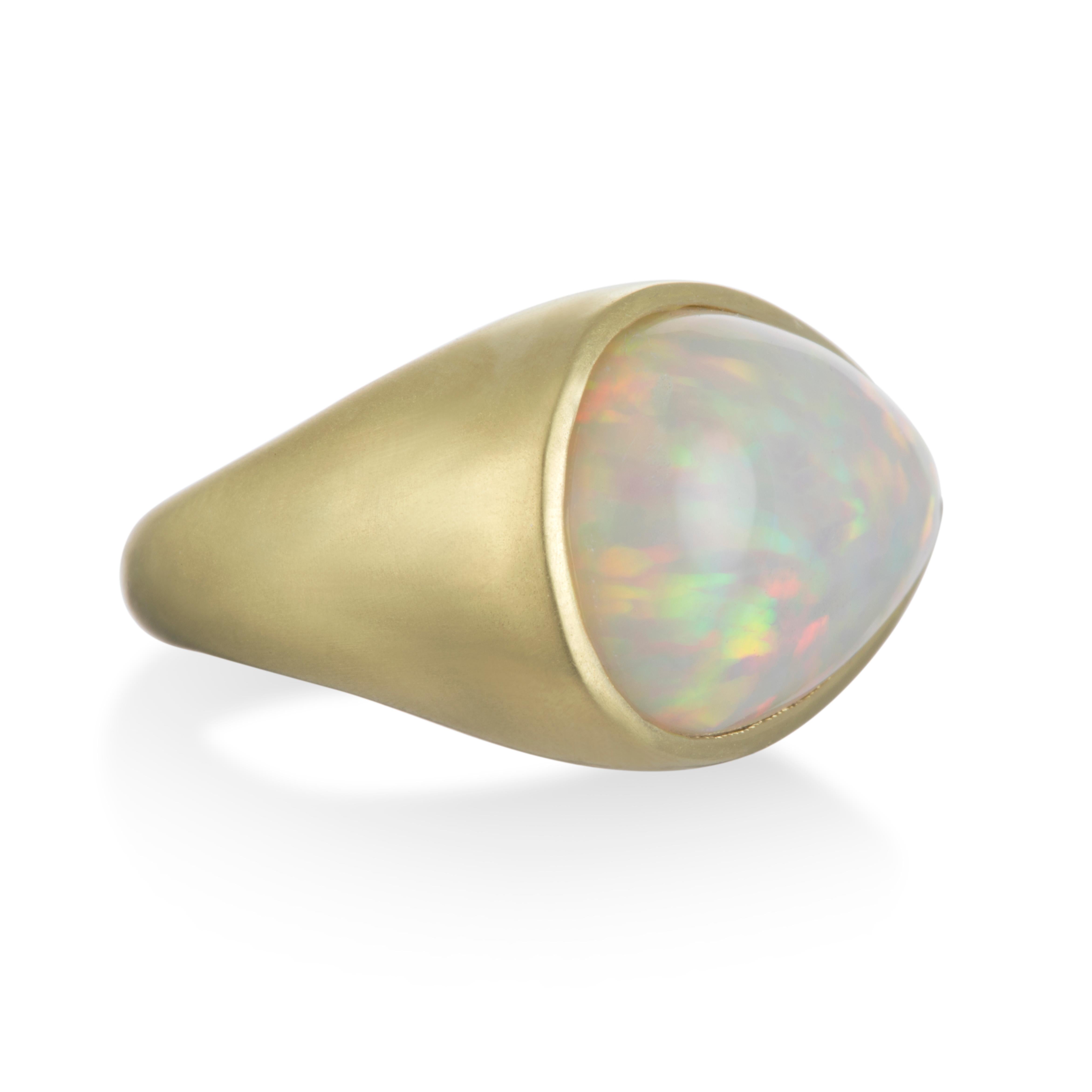 Experience luxury with Faye Kim's 18 Karat Gold Bezel Set Opal Ring.  For those lucky enough to be born in October, here is a true one-of-a-kind treasure and the perfect birthstone ring. Lively color of play with red and green flashes. 