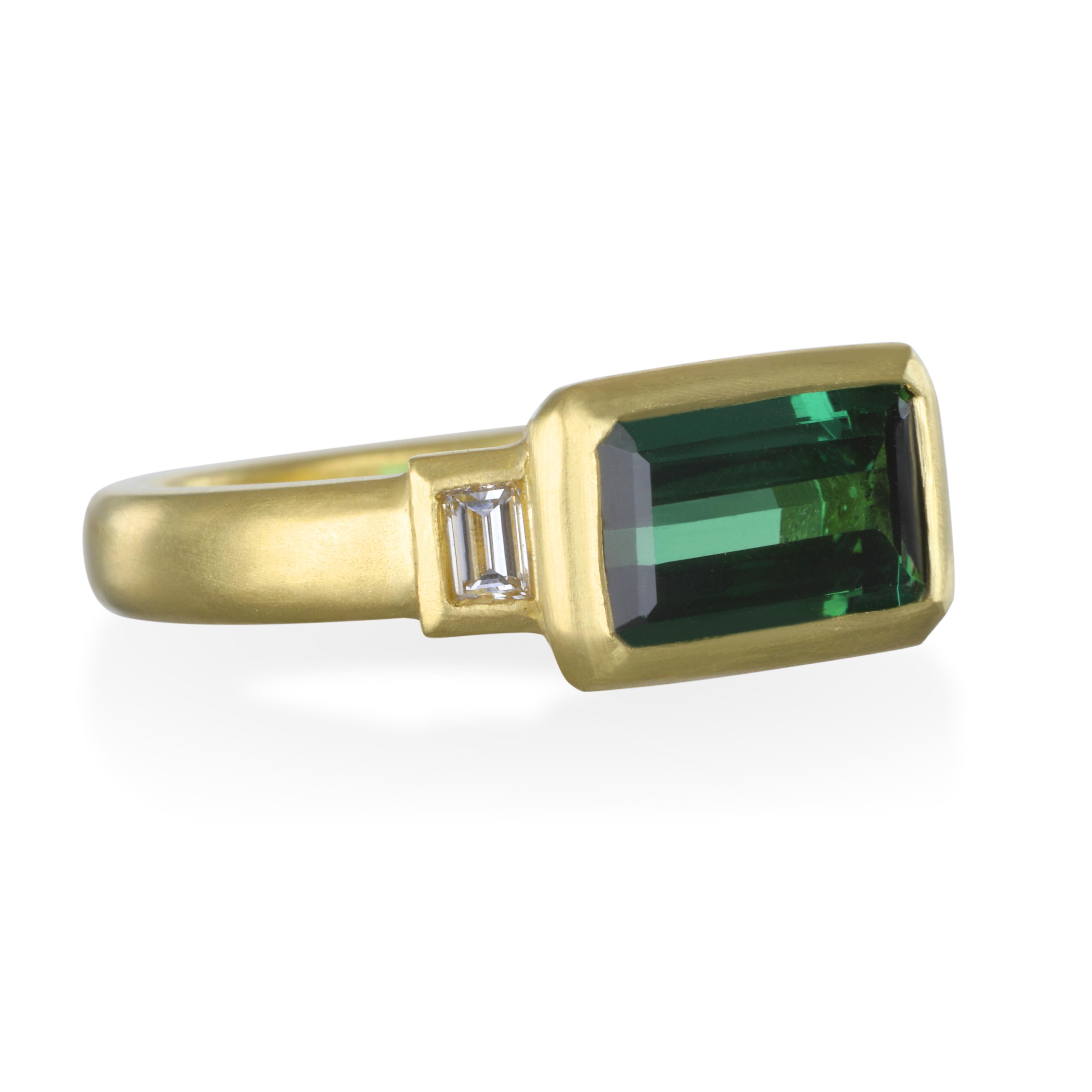 One of a Kind:
Faye Kim's 18k gold Green Tourmaline ring has exceptional even color, with a touch of Blue undertone that is highlighted by the Emerald cut and white diamond baguettes. A modern-day classic!

Size 7
Green Tourmaline 2.35 carats 