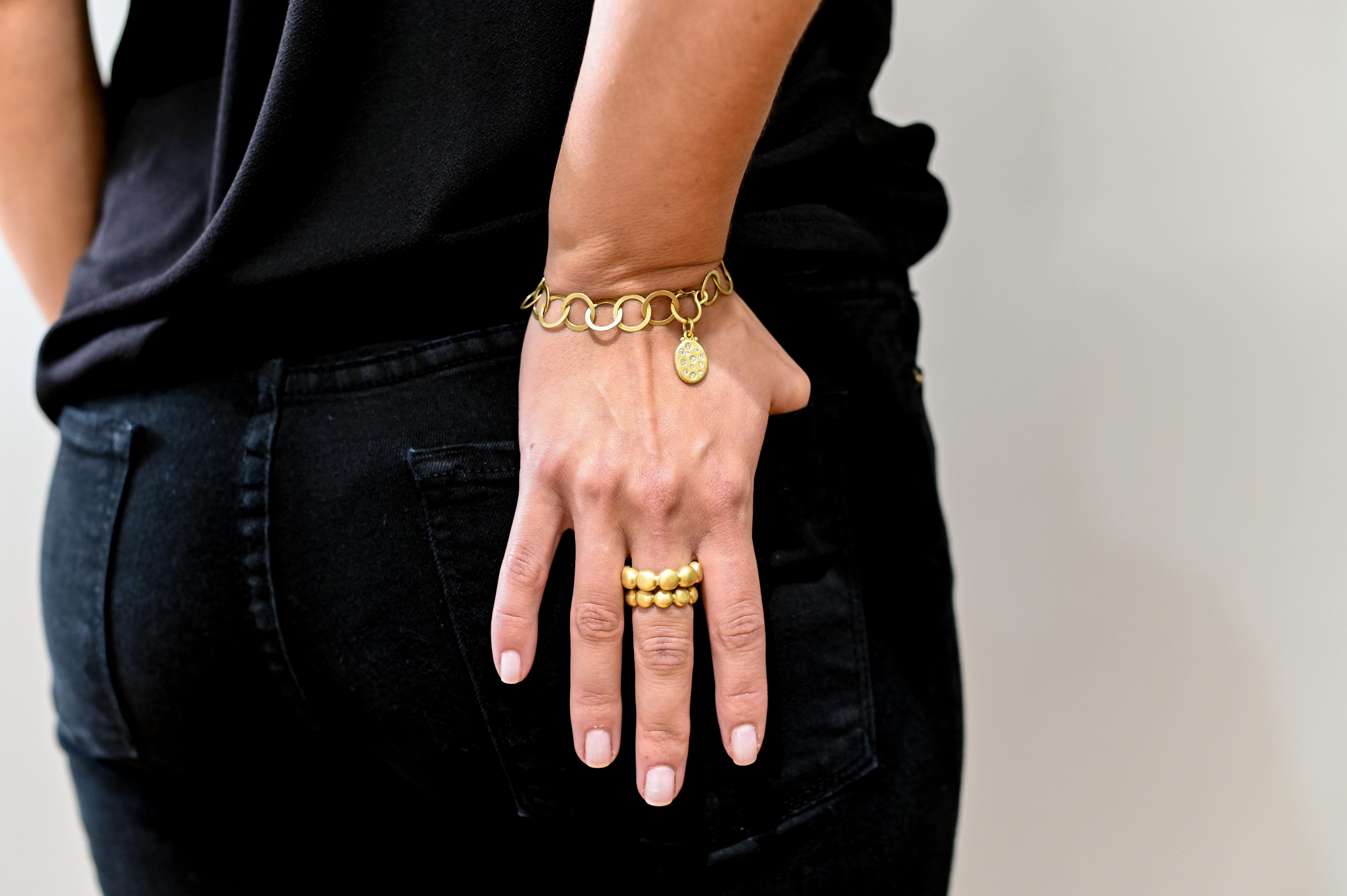 Handmade in 18K Green Gold, Faye Kim's chain link is bracelet is planished and matte-finished for a fresh, modern feel. The safety clasp adds extra security and can be used to display a variety of charms to help personalize your look.

Photographed