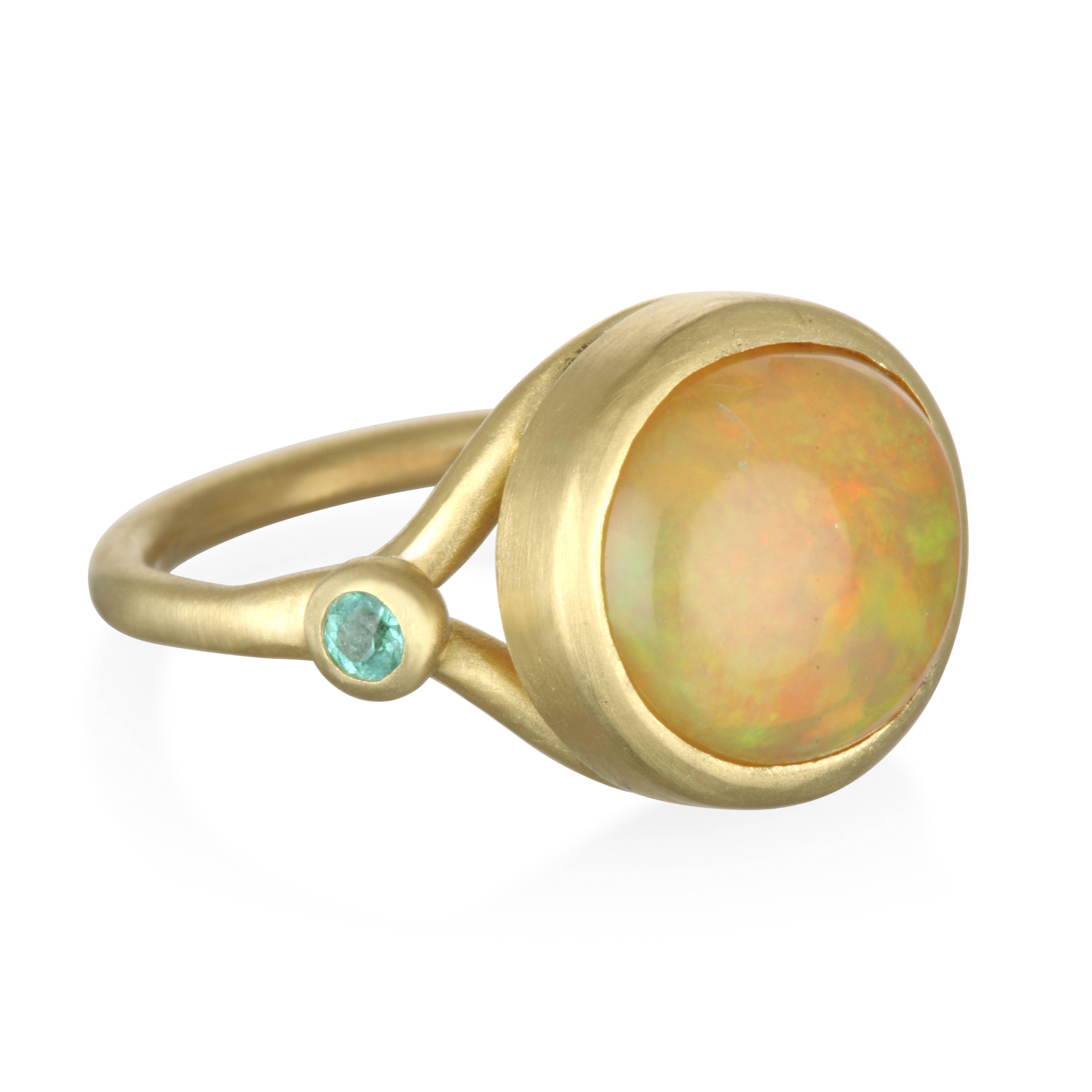 Faye Kim 18k Gold Round Mexican Opal Cabochon and Paraiba Tourmaline Ring.
The beautiful color contrast between the bright blue-green Paraiba tourmalines and the Opal perfectly complements one another in this striking Mexican Opal Cabochon and