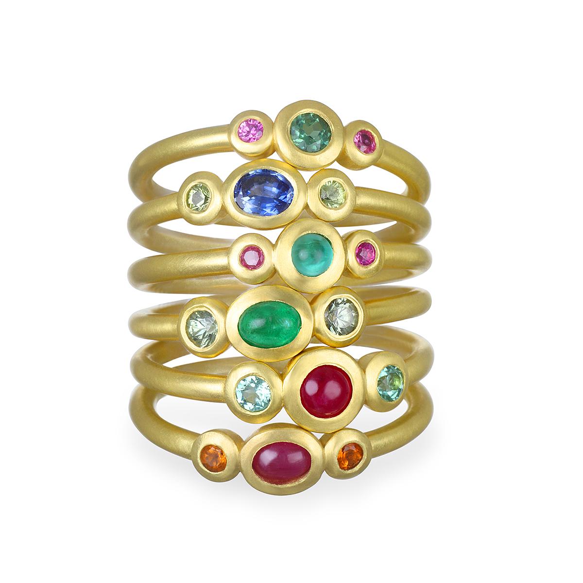 A vibrant oval shaped ruby flanked by sparkling mandarin garnets. This three stone ring is beautifully crafted, bezel set and matte-finished.  Wear alone or stacked with other rings to elevate your individual style!

Handcrafted in 18k green gold,