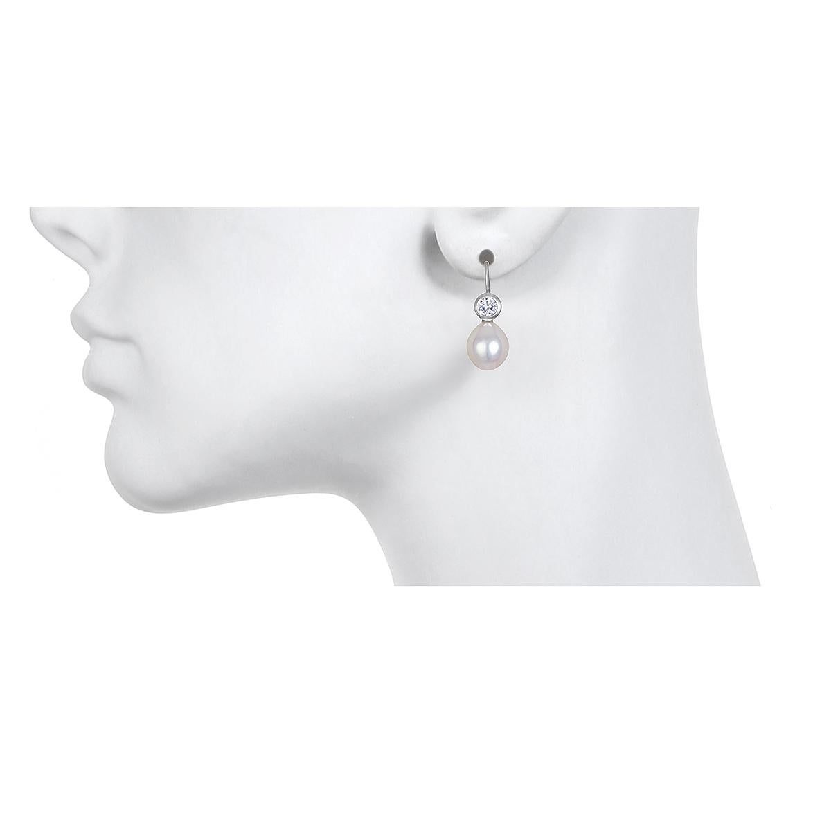 Set in 18k white gold, White Sapphire is paired with white freshwater pearls to create a pair of modern-day classic drop earrings.  Matte-finished.
Casual or corporate, the clean design is flattering and simply beautiful!  French ear wires.  

Model