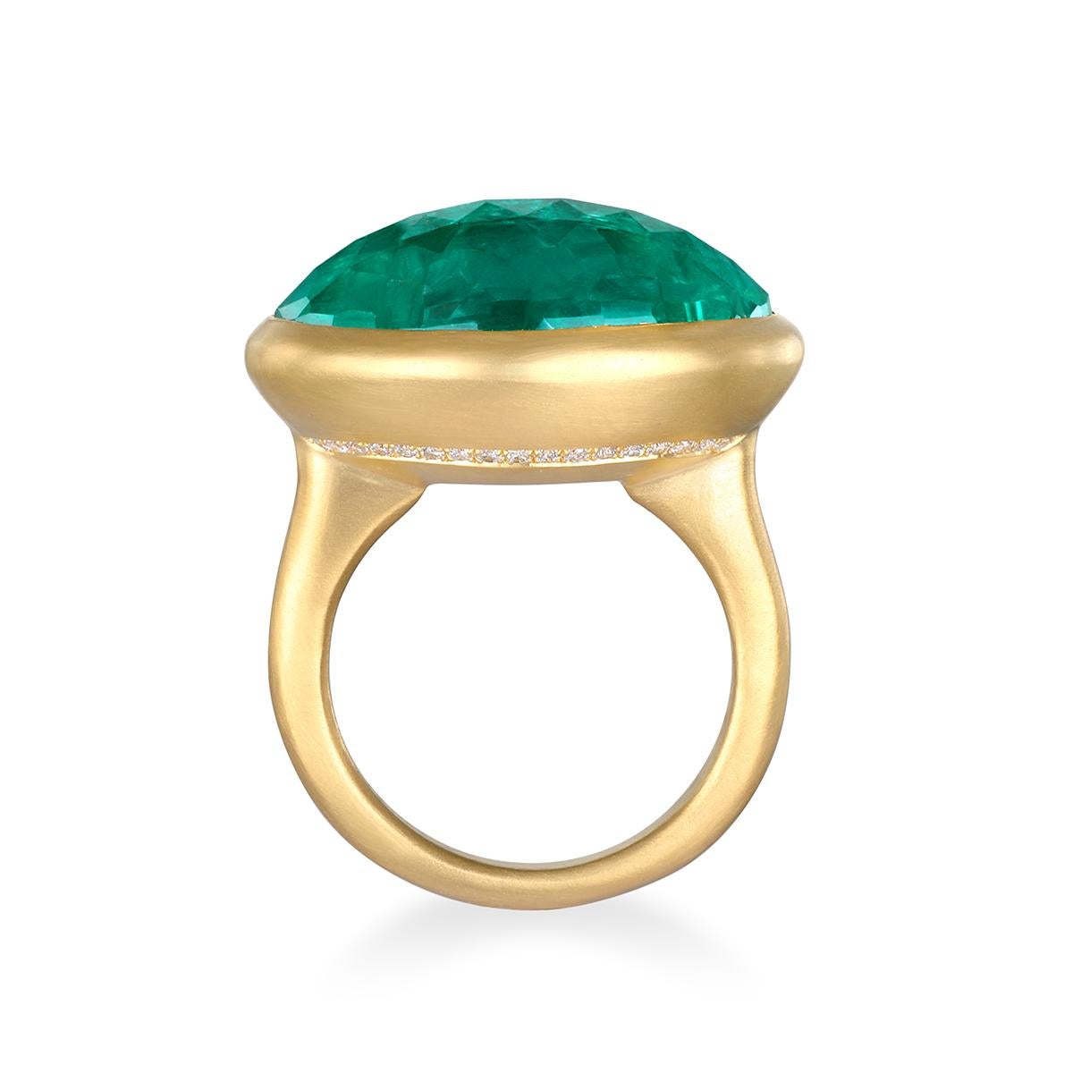 Dieser Ring von Faye Kim ist eine elegante Studie in Farbe und Handwerkskunst. Er zeigt einen ovalen kolumbianischen Smaragd im Rosenschliff, der in 22-karätigem Gold gefasst ist. Das leuchtende Grün des Smaragds wird sanft von einer von Hand