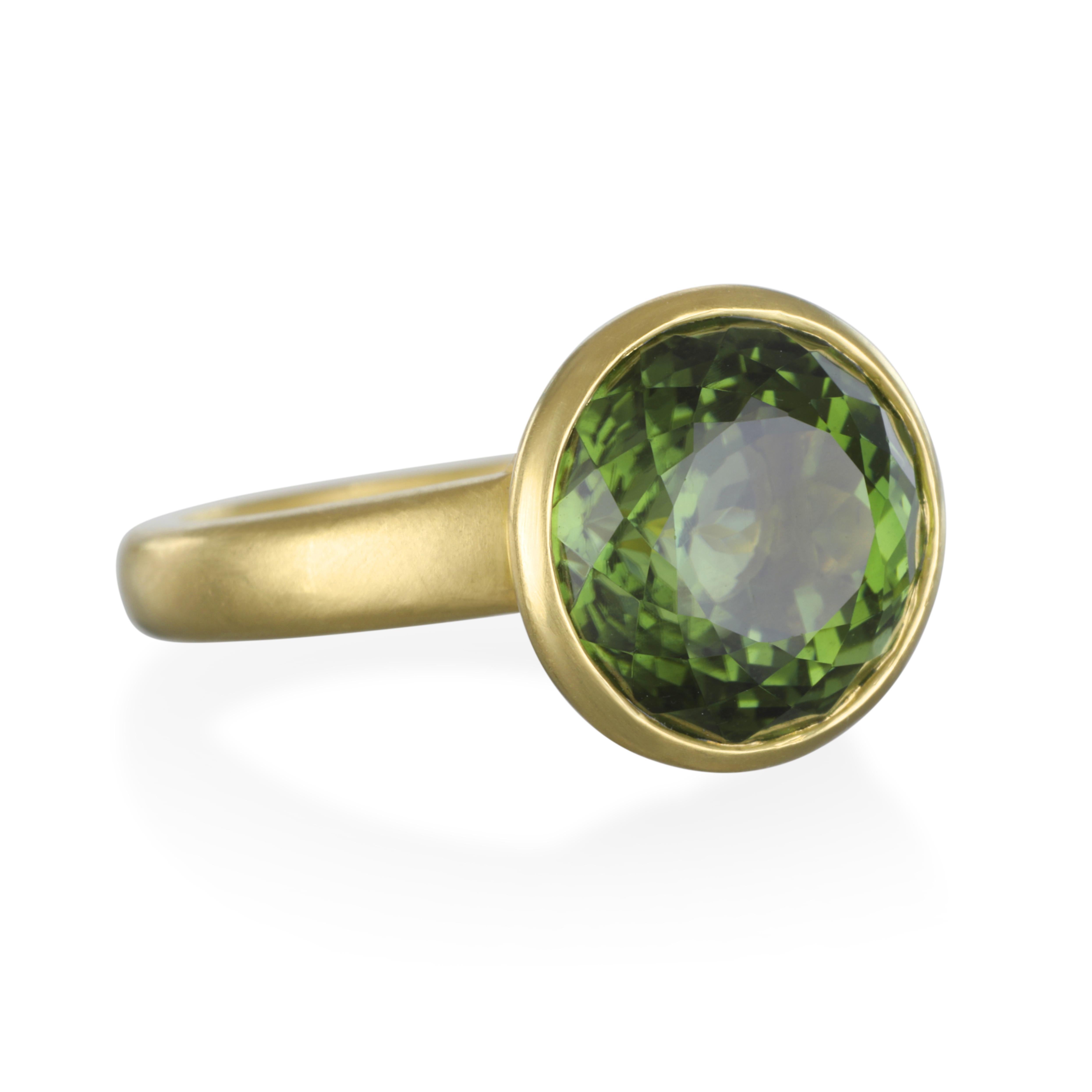 Portuguese Cut Green Round Tourmaline Ring in 18k Gold.
The rich green color and skillful Portuguese cut on this tourmaline combine elegantly in this simple and clean design. The term Portuguese cut refers to the extra row of facets that can be seen