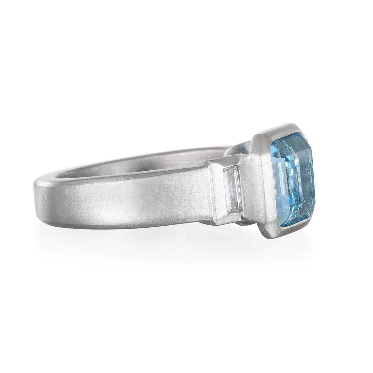 Designer Faye Kim had set this spectacular aquamarine in matte-finished platinum and paired it with two side diamonds. Used in jewelry since at least 500 BC, aquamarine's tropical ocean blue tones effortlessly invoke images of landless skies and the