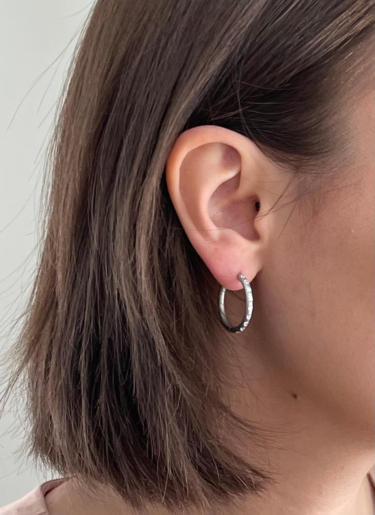 Elaborado a mano en platino, el moderno diseño de aro de Faye Kim transmite una elegancia discreta y un aspecto cotidiano realmente elegante. Los aros son macizos con un mecanismo de bisagra, con un acabado bruñido y destellos de microdiamantes