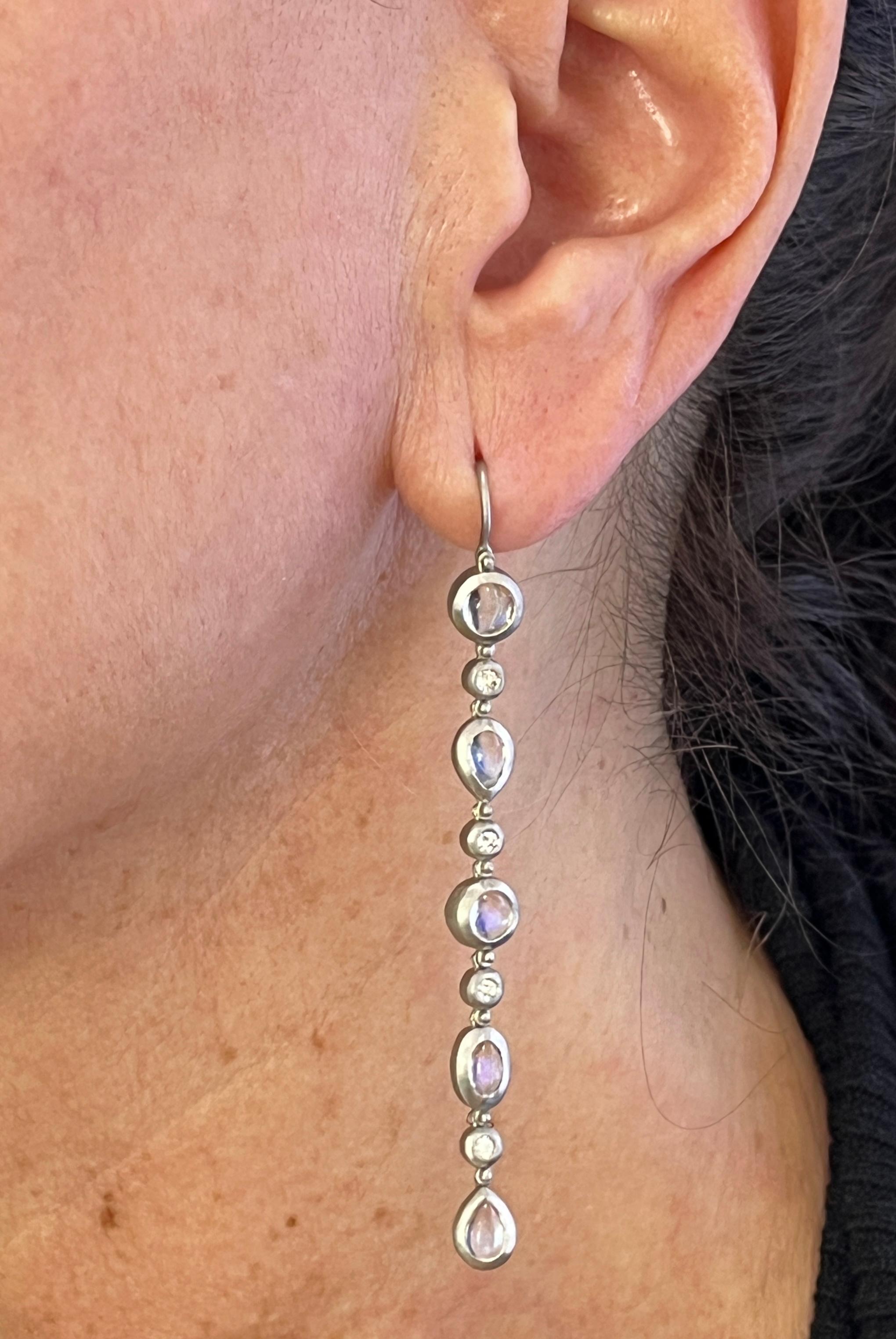 Faye Kim's Platinum Diamond Ceylon Moonstone Line Earrings are beautifully crafted and showcase spectacular round, oval and pear-shape moonstones separated by sparkling round white diamonds. Perfect for every occasion!

Moonstones 5 tcw
Diamonds .25