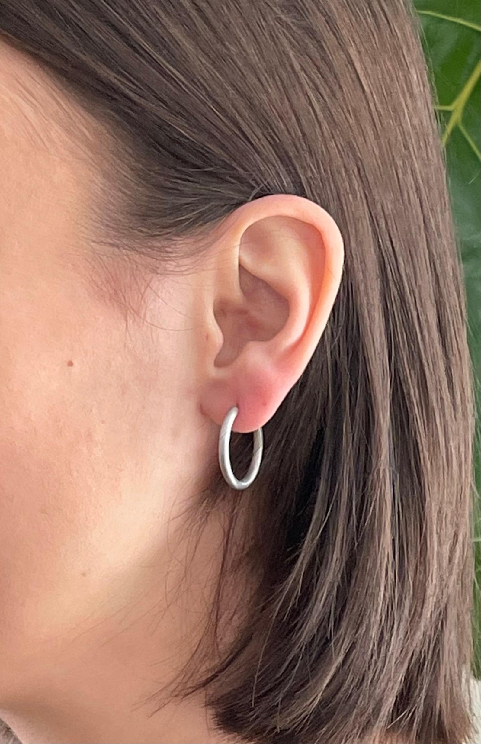 Handcrafted in platinum, Faye Kim’s modern hoop design, with its matte finish, conveys understated elegance and a truly stylish, everyday look! Hoops are solid with a hinged mechanism, and are available in other metals and finishes.

Diameter .75