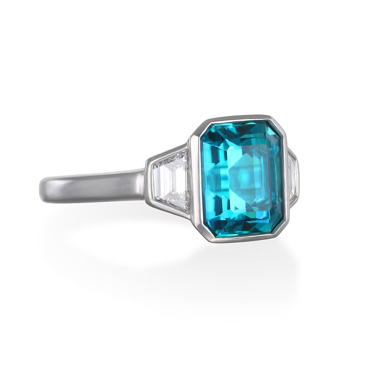 A rich shade of blue-green, Faye Kim has set this spectacular Emerald Cut Indicolite Tourmaline in platinum and flanked it with two diamond baguettes, all in an open bezel setting. Modern yet with an Art Deco/vintage feel and matte finished, this