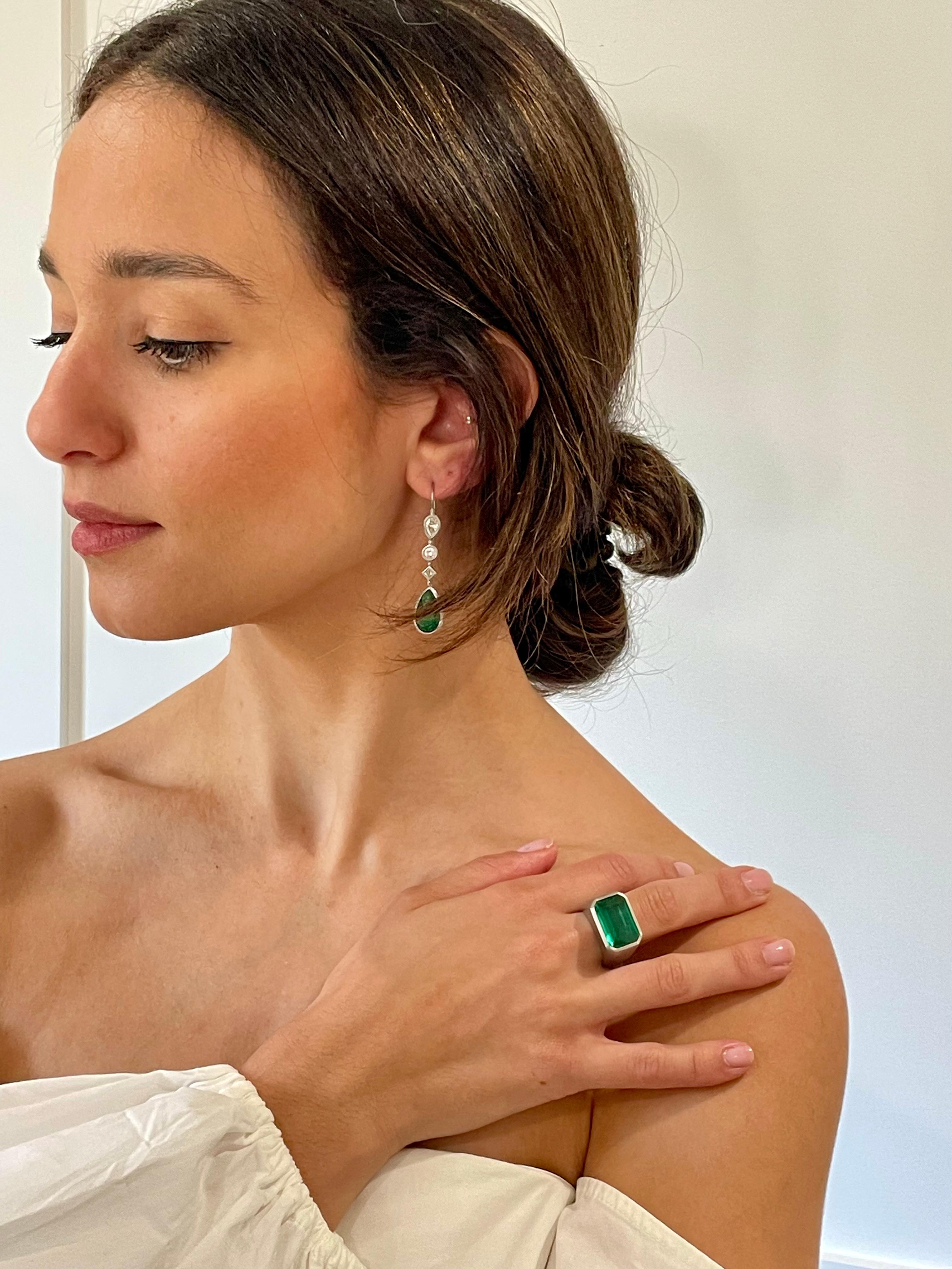 Faye Kim's one-of-a-kind Platinum Pear Shape Emerald Diamond Earrings comprise bright and beautiful twin emeralds each paired with a line of striking white diamonds in various shapes. The statement-making set is simultaneously classic and timeless