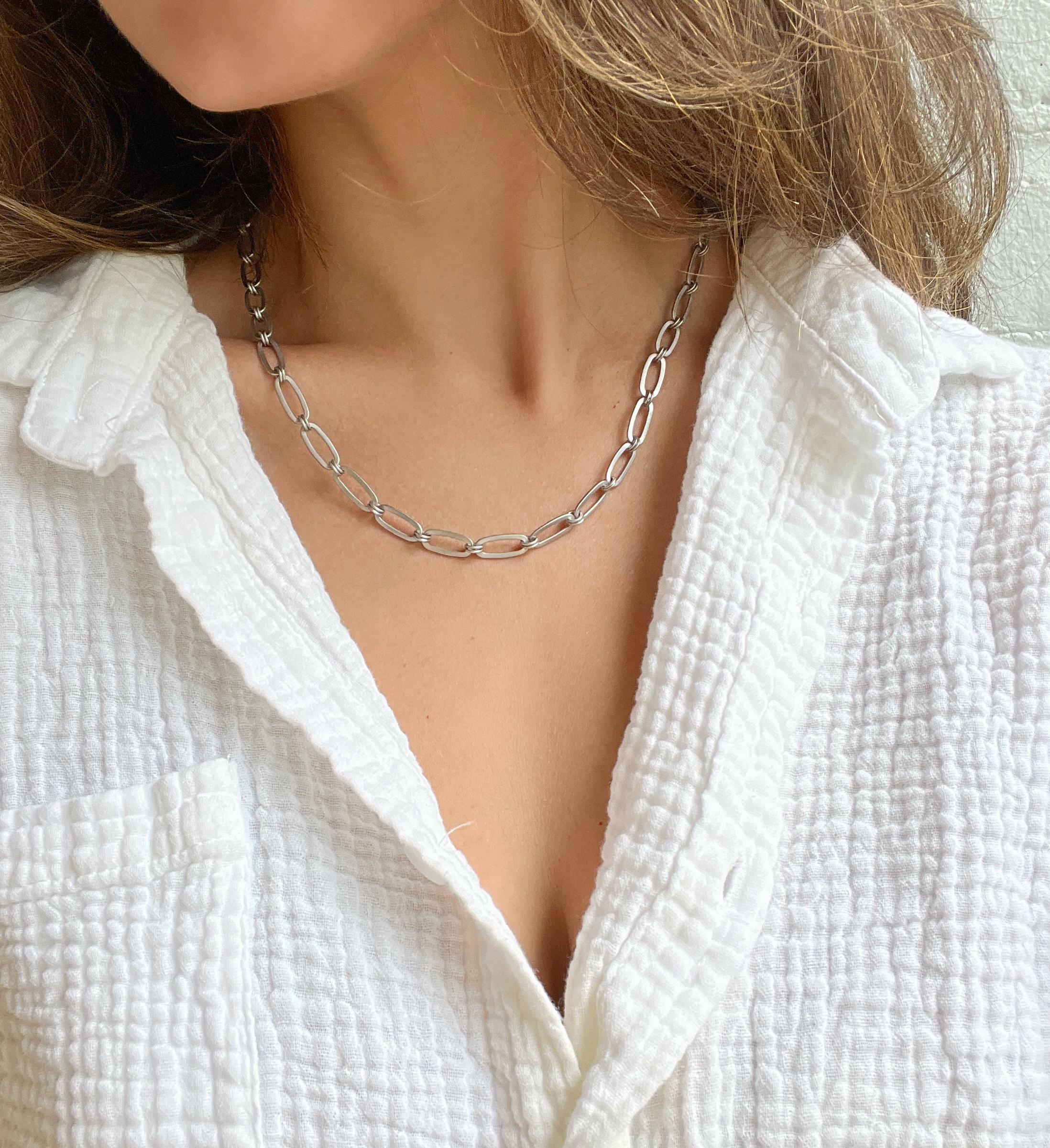 Classique et polyvalente, la chaîne en forme de trombone à maillons ronds planés en platine de Faye Kim est indispensable à toute garde-robe de bijoux. Cette pièce polyvalente peut être portée seule ou en superposition avec d'autres chaînes et/ou un