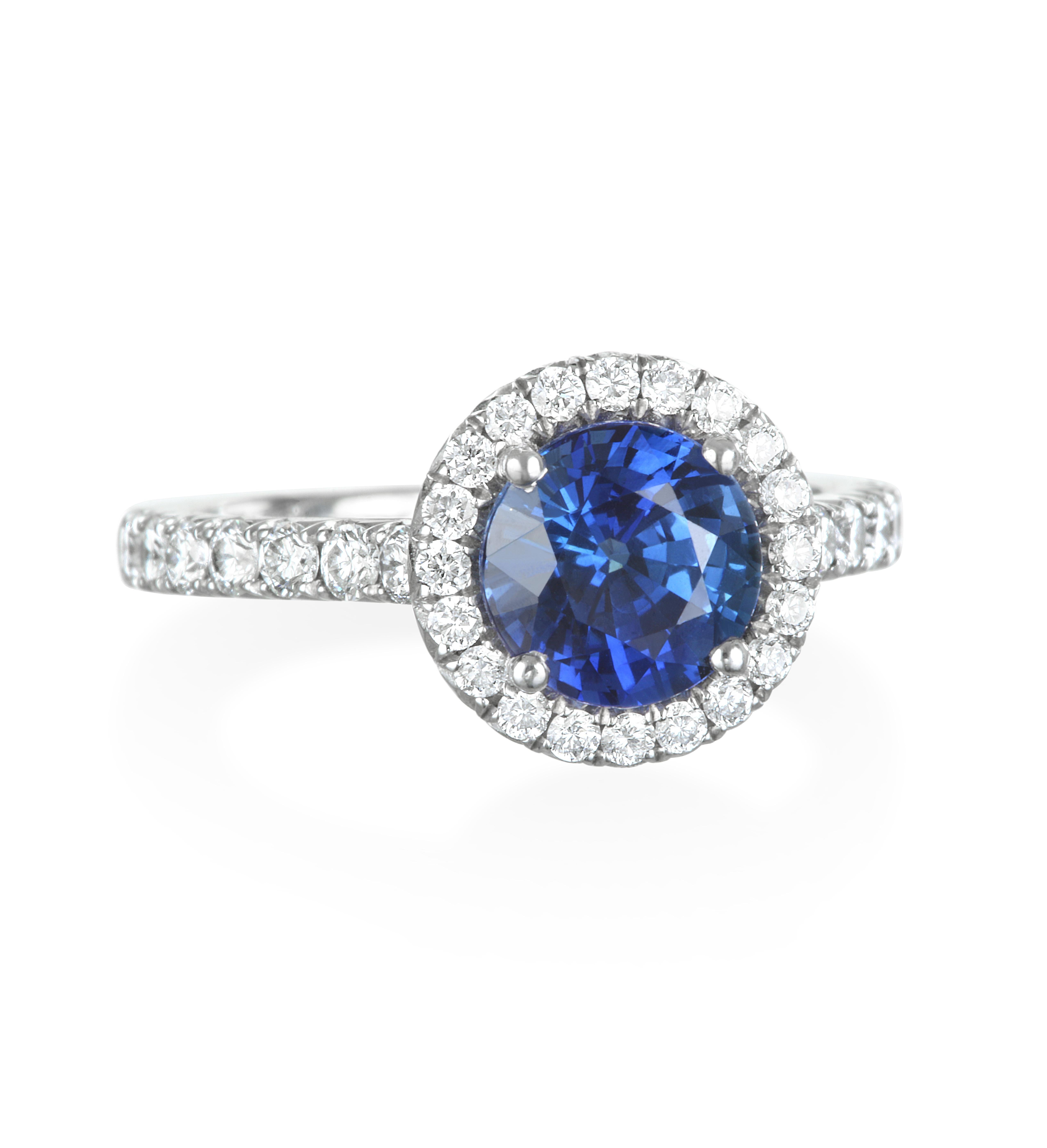 Faye Kim Platinum Blue Sapphire Diamond Halo  Engagement Ring.

Features a striking blue sapphire that is characteristic of Ceylon sapphires -beautifully handcrafted in platinum,  framed by a micro pave diamond halo and shank. Sapphires are