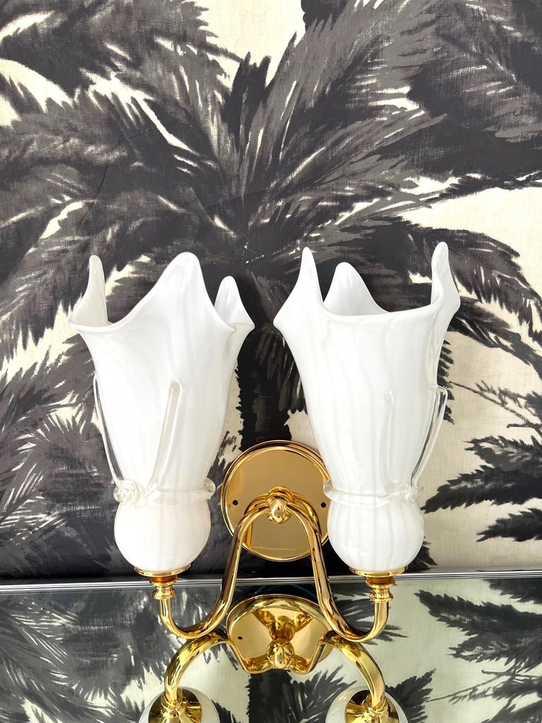 1980's Venini Style Murano glass double sconce.   The sconce features two handblown shades in white opaque glass with fluted details and with stripes.  The 24-karat gold plated frame has a round backplate with stylized scrolled arms.  The