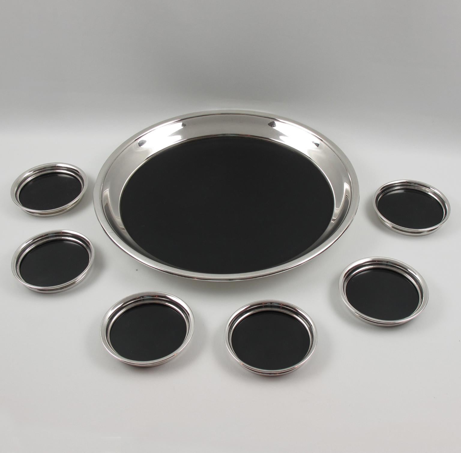 Elegant modernist barware set, comprising a rounded serving or bar tray and six coasters, manufactured by F.B. Rogers Silver Co. Black bakelite bottom insert for each piece that sits inside a polished silver plate metal surround. The exterior of the