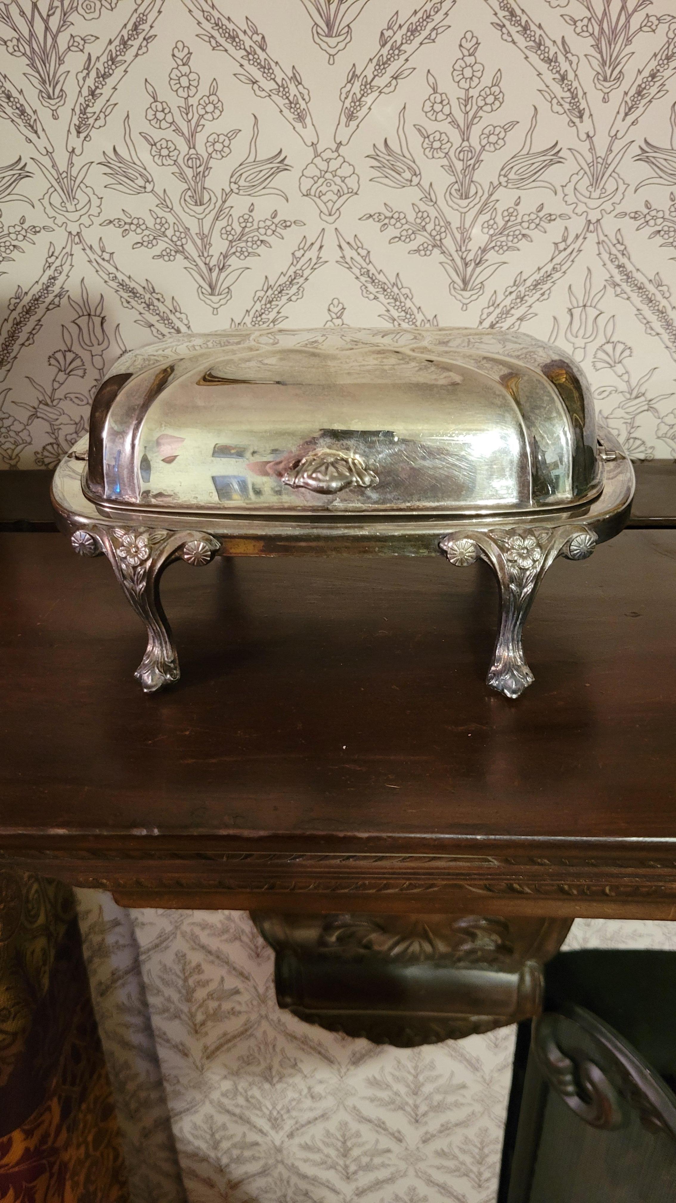 Une belle F.B.I. Beurrier Rogers en métal argenté (métal argenté sur cuivre) avec couvercle.
Le beurrier est conçu dans un style antique qui pourrait être attribué à la haute époque victorienne et a été fabriqué avant 1955.
Très bon état.


