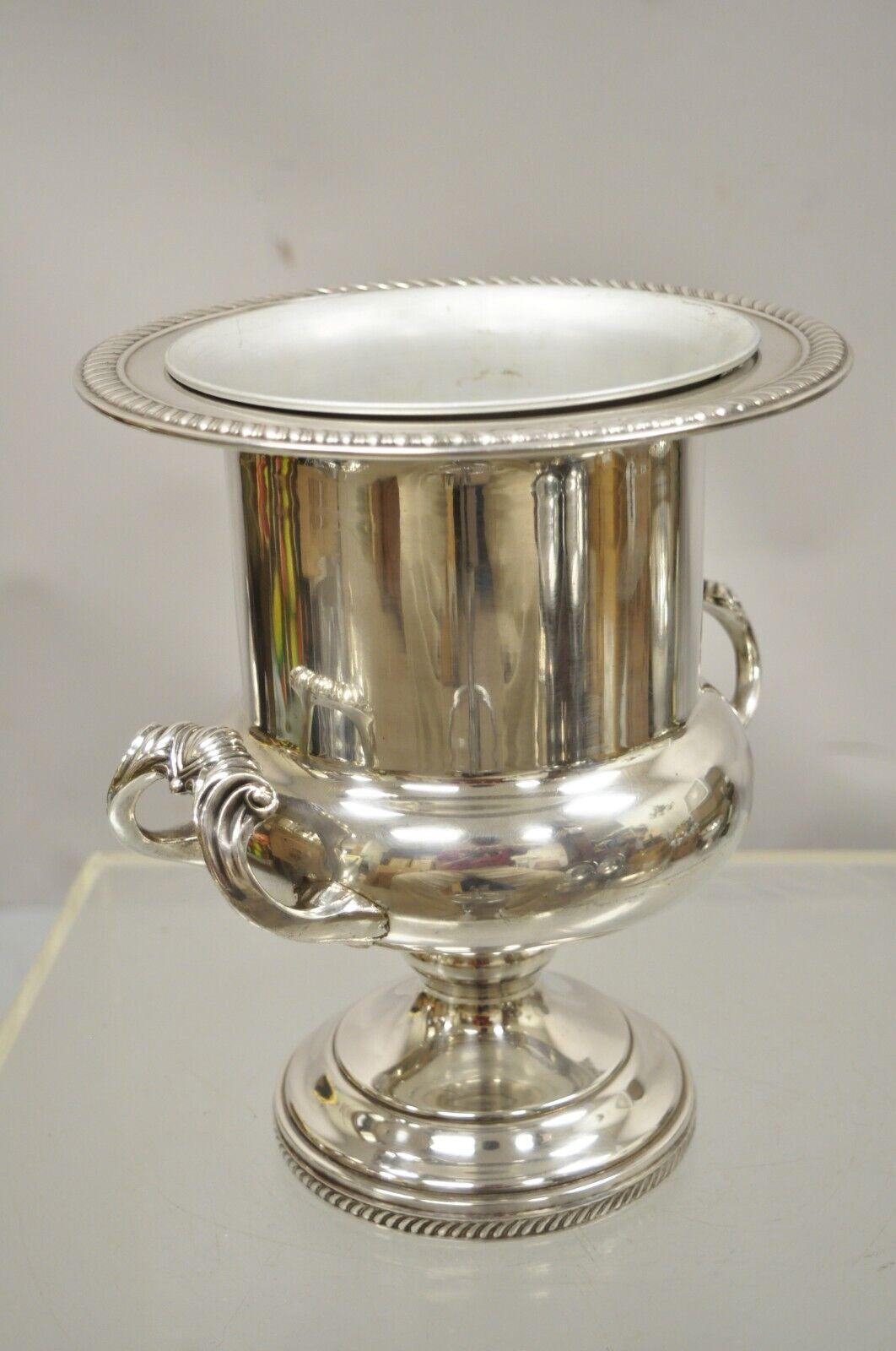 F.B. Rogers trophy cup silver plate champagne bucket wine ice bucker. Item features removable liner, ornate handles, trophy cup form, original stamp. Circa mid 20th century. Measurements: 10.5