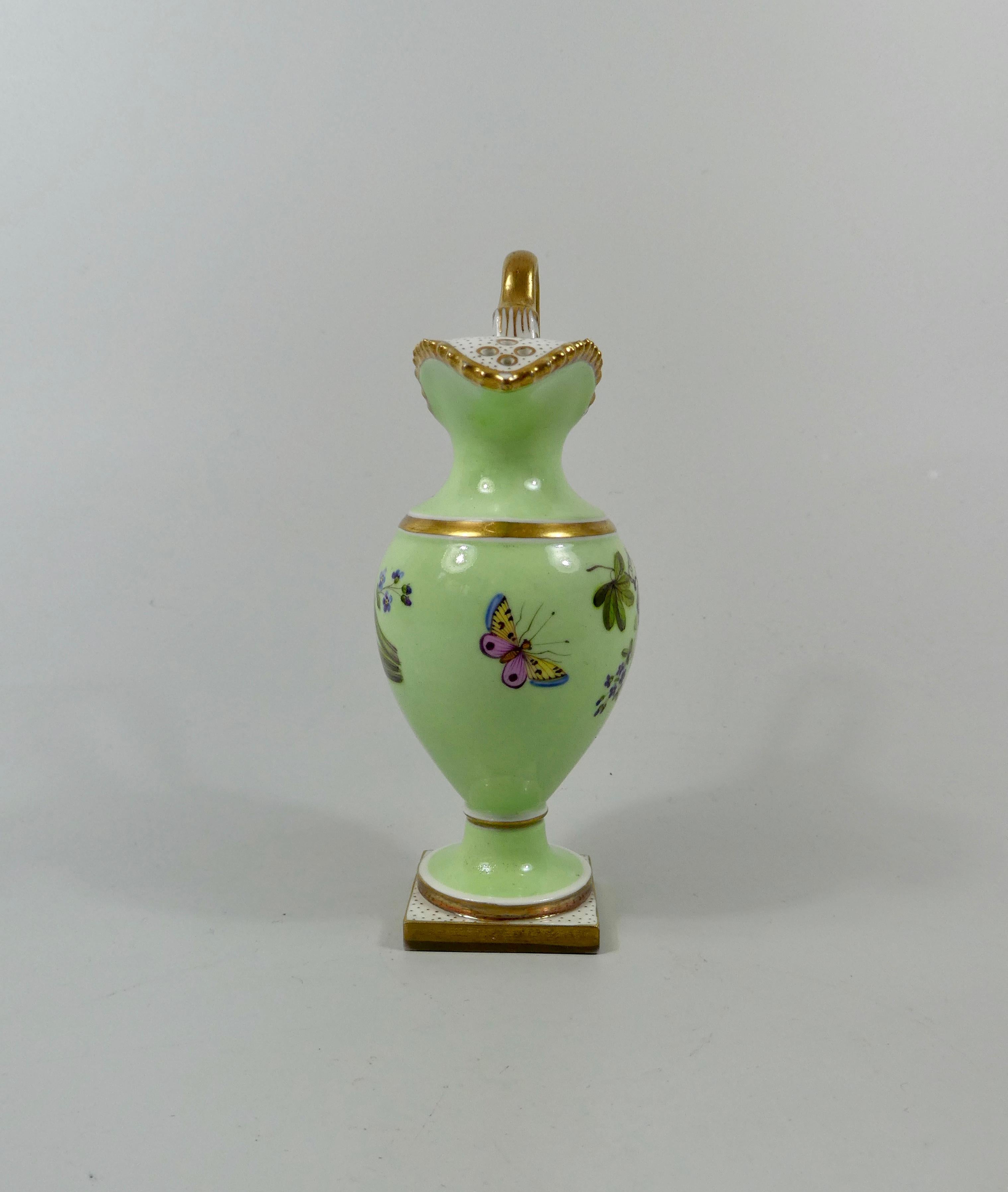 Flight Barr and Barr Worcester porcelain miniature rose water sprinkler, circa 1810. Finely painted with sprays of flowers, on an apple green ground, and a large butterfly beneath the spout. The gilt gadrooned rim, having a pierced spout, and