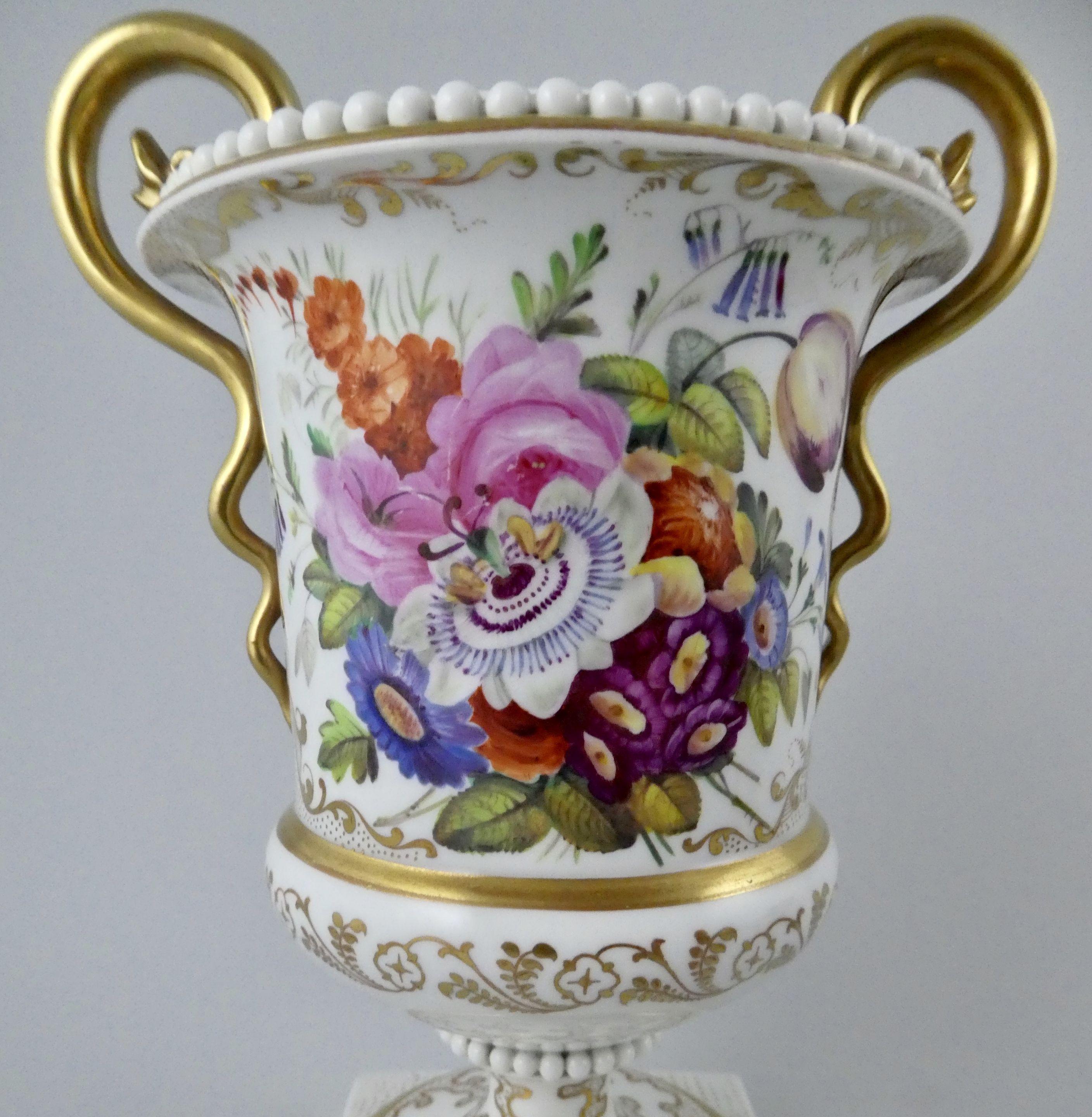 Flight Barr and Barr Worcester porcelain vase, circa 1810. The urn shaped vase, finely painted with a study of a spray of flowers upon a white ground, further embellished with an elaborate gilt pattern. Having twin gilt serpent handles, and beadwork