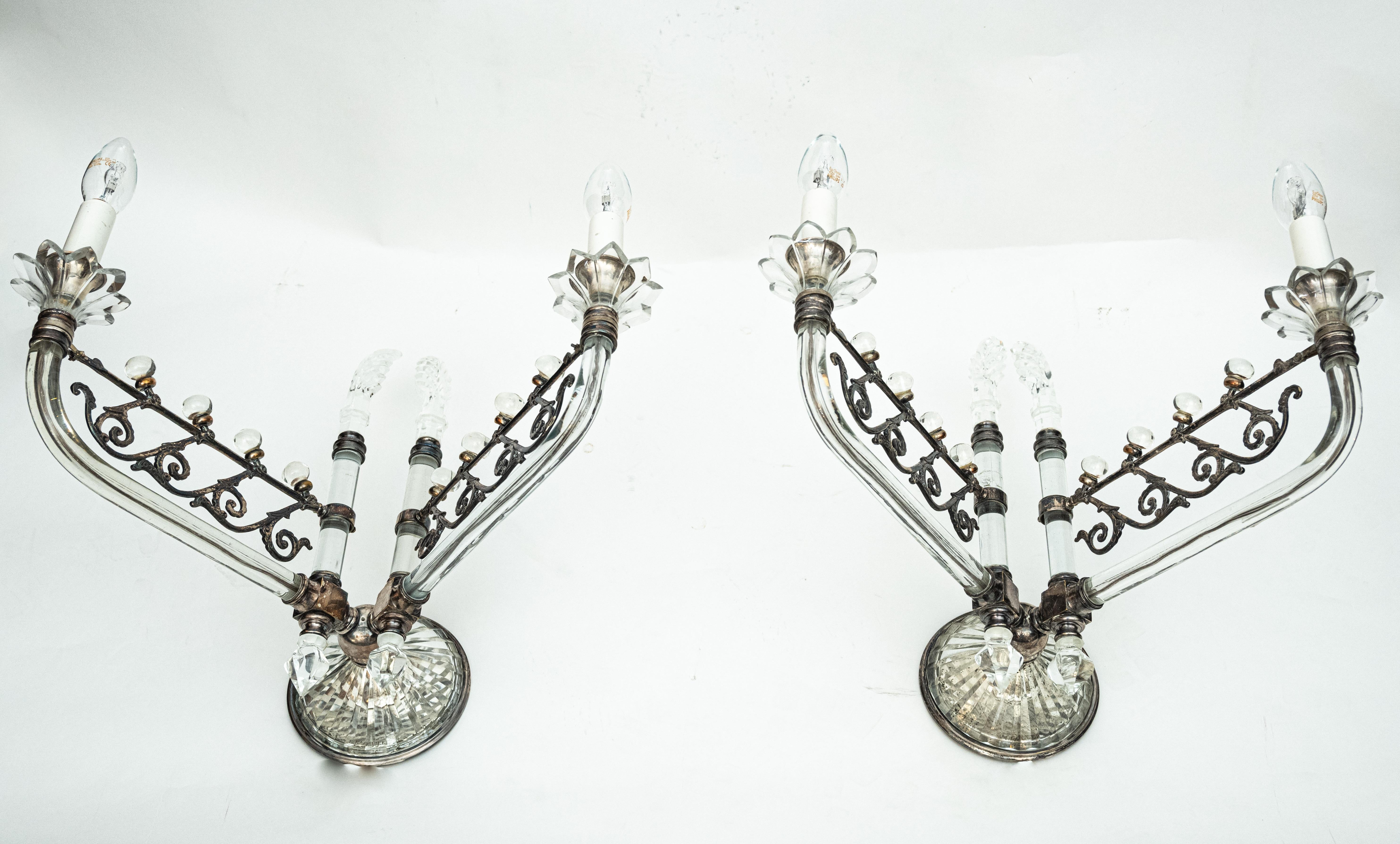 A pair of Edwardian style sconces by F&C Osler. Two silver embellished glass arms support candelabra sockets. Ornate silver lugs terminate in cut crystal elements and the makers mark is visible through the cast backplate. Circa 1910.

