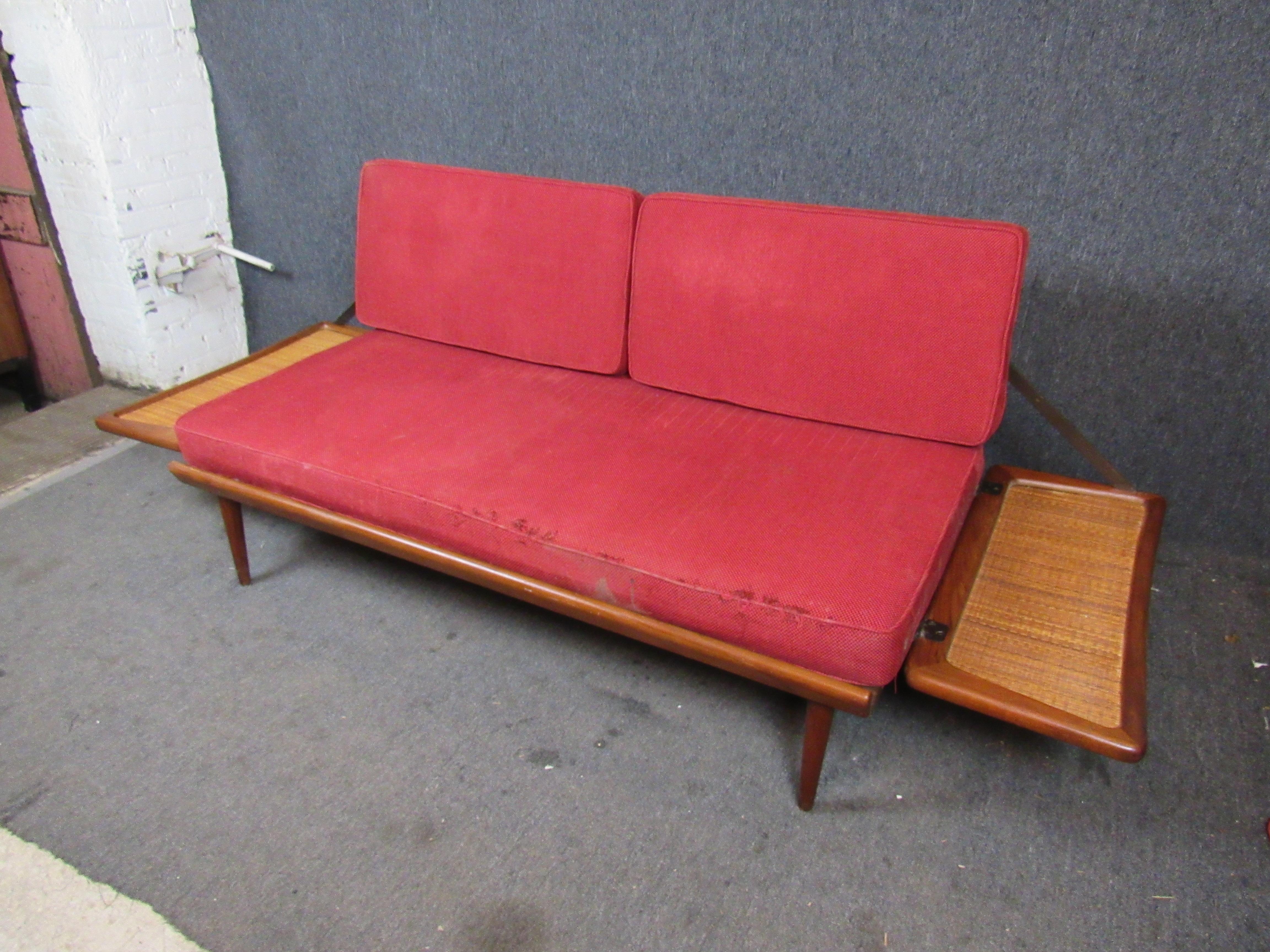 Bring home timeless Danish design with this ingenious vintage daybed by Peter Hvidt and Orla Mølgaard for France & Søn/John Stuart. The funky trapezoidal teak & cane arms can slide down to convert this two seat sofa into a twin sized day bed.