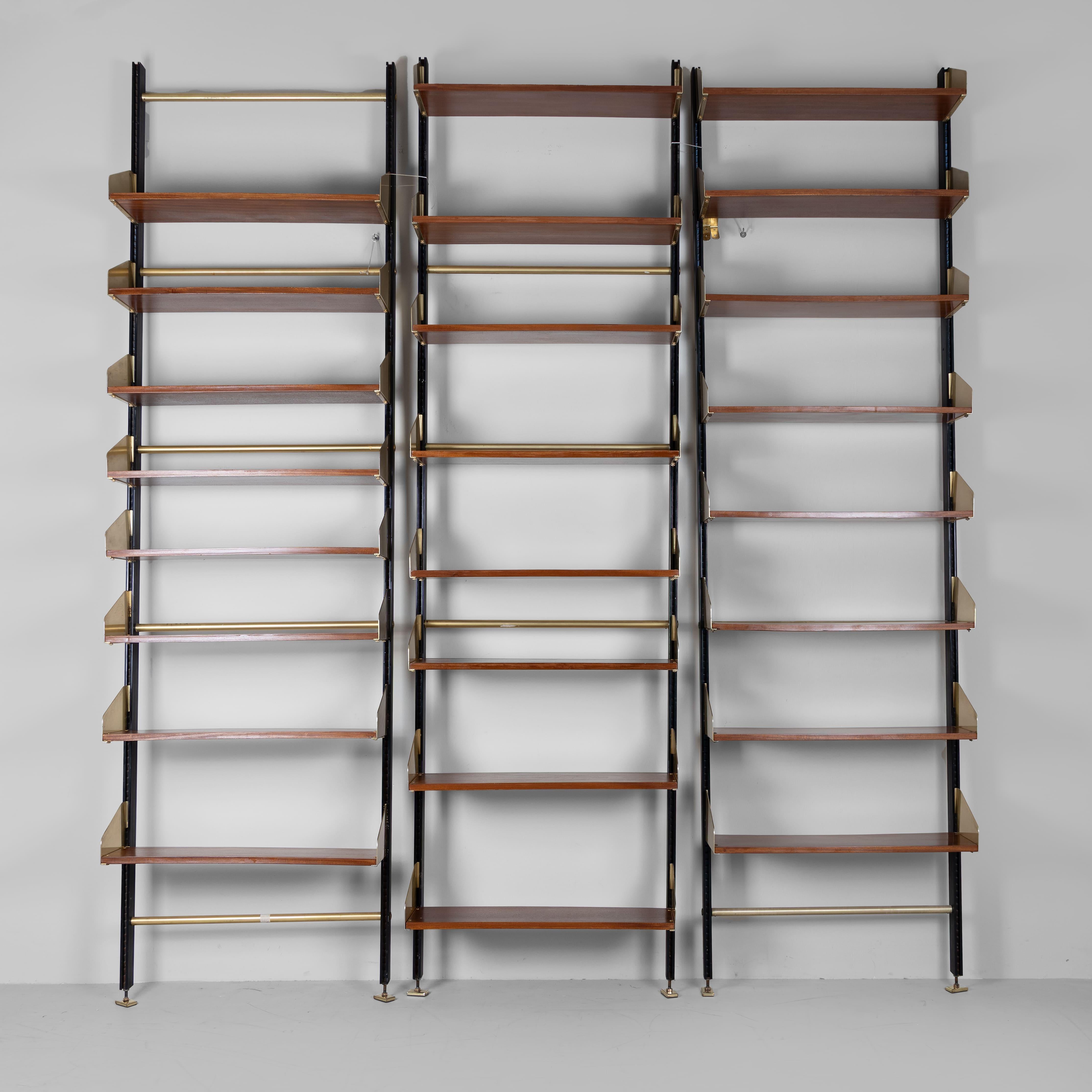 Librerie modello FEAL 1960, set di 3. Possibilità di aggiungere un modulo contenitore e una scrivania. Realizzata con una struttura in metallo e legno, questa libreria è caratterizzata da un sistema di montanti che ti permettono di organizzare