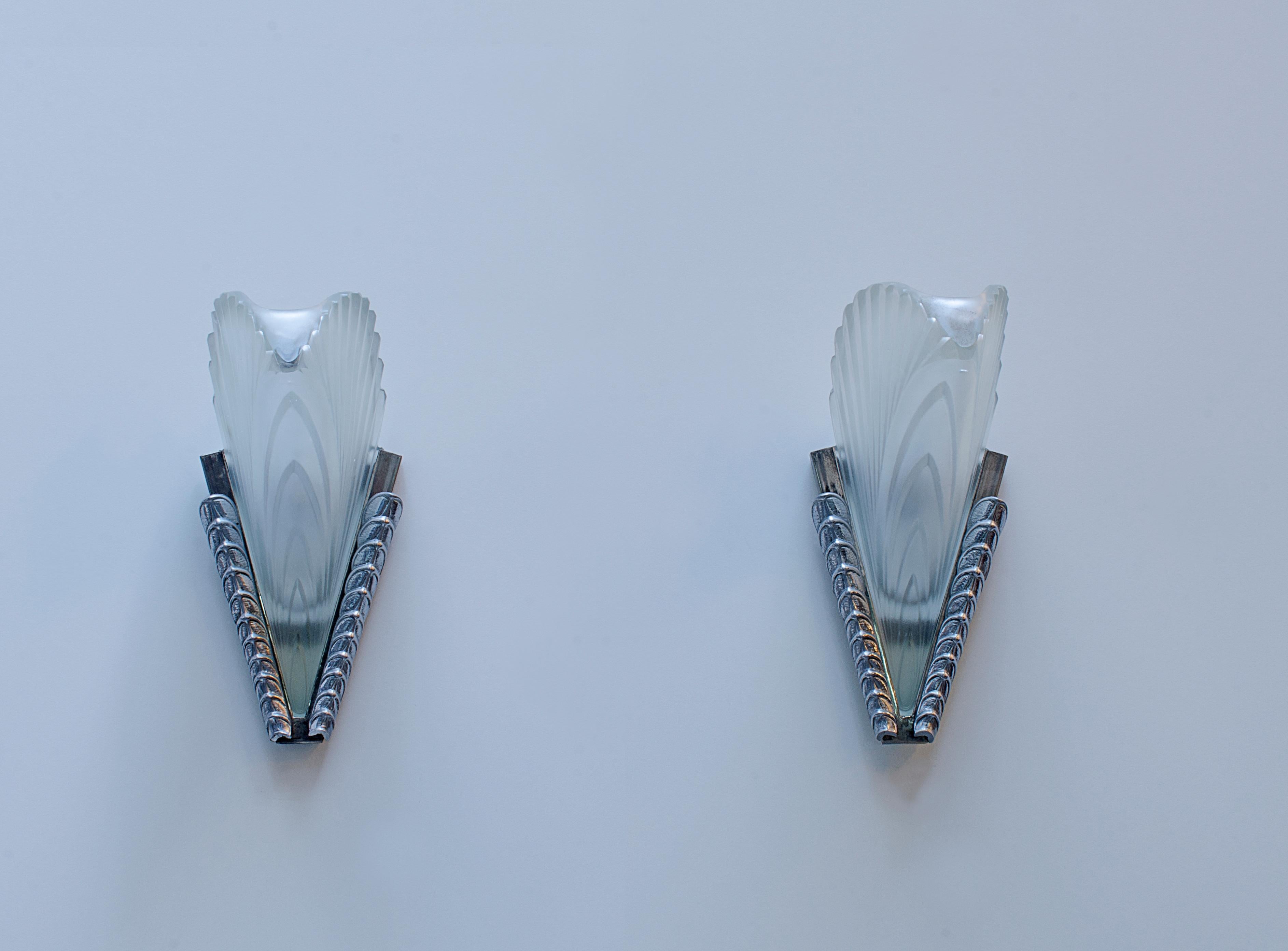 Pair of silver-plated bronze sconces, with satin glass plates in the shape of a feather, Attributed to Freres Simonet (1919-1970)

France, circa 1920.